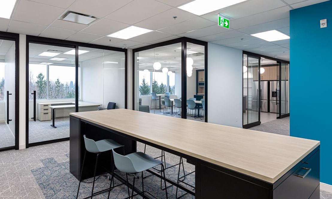 There is a long table with chairs in the middle of the room.