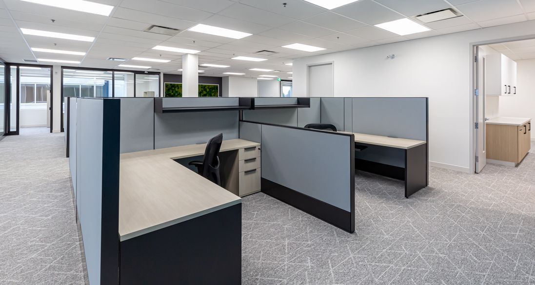 A large empty office with cubicles and desks.