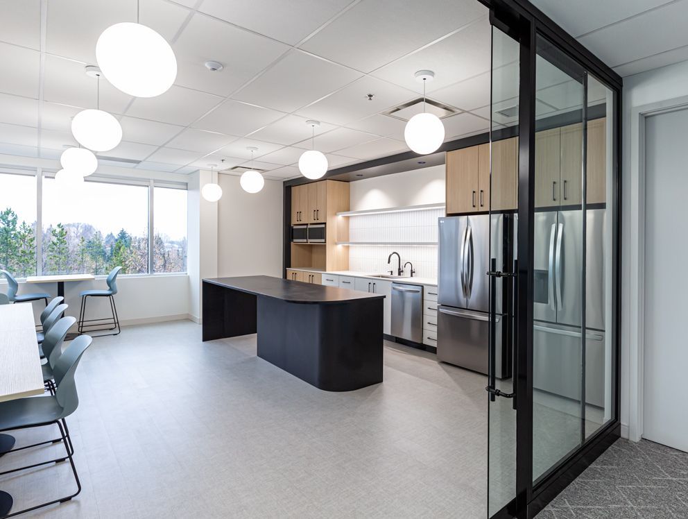 A kitchen with stainless steel appliances and a large island in the middle of the room.