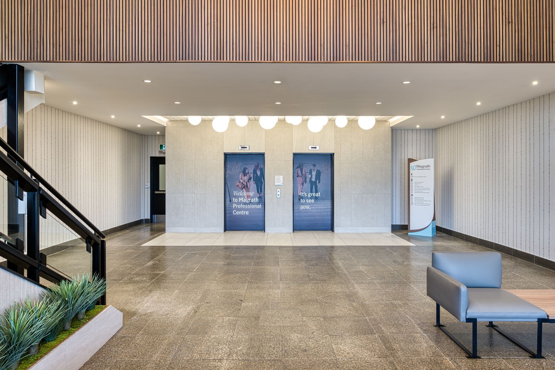 A lobby with two elevators and a chair in it