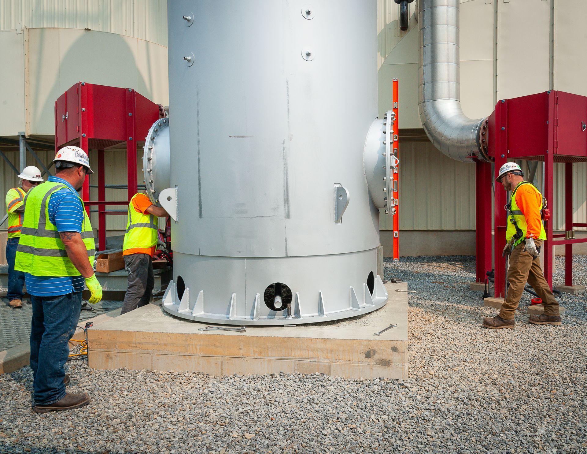 A group of construction workers are working on a large metal structure.