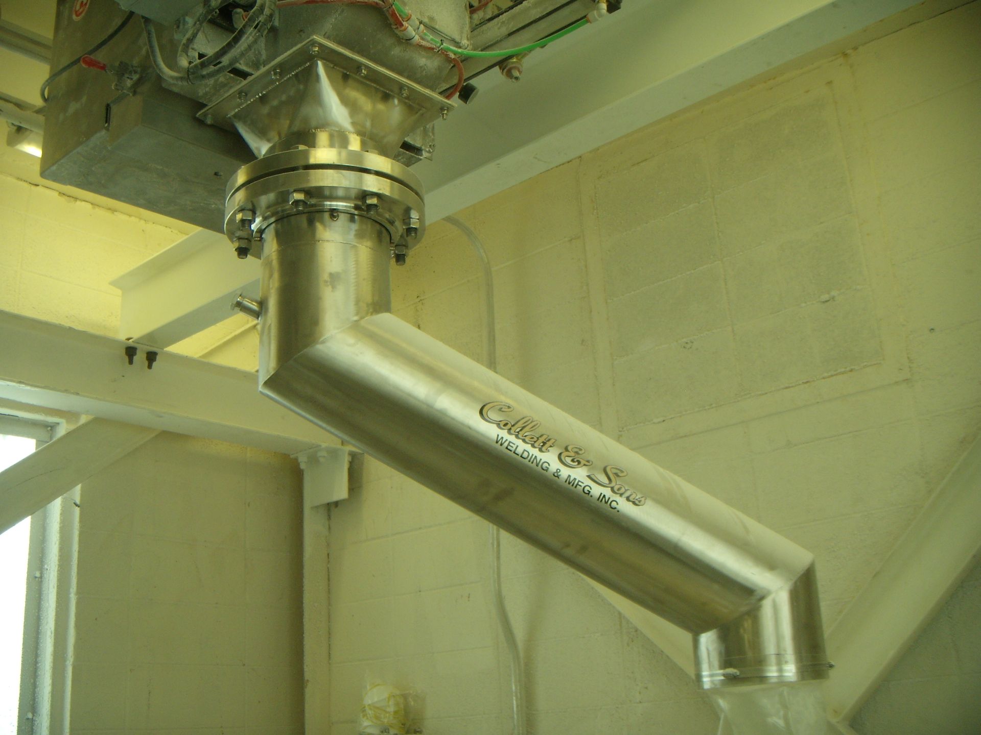 A stainless steel pipe is hanging from the ceiling of a building.