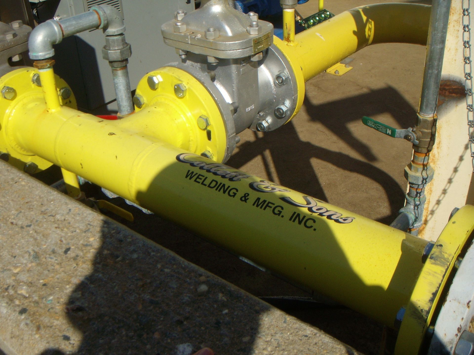 A yellow pipe with welding & mfg inc. written on it