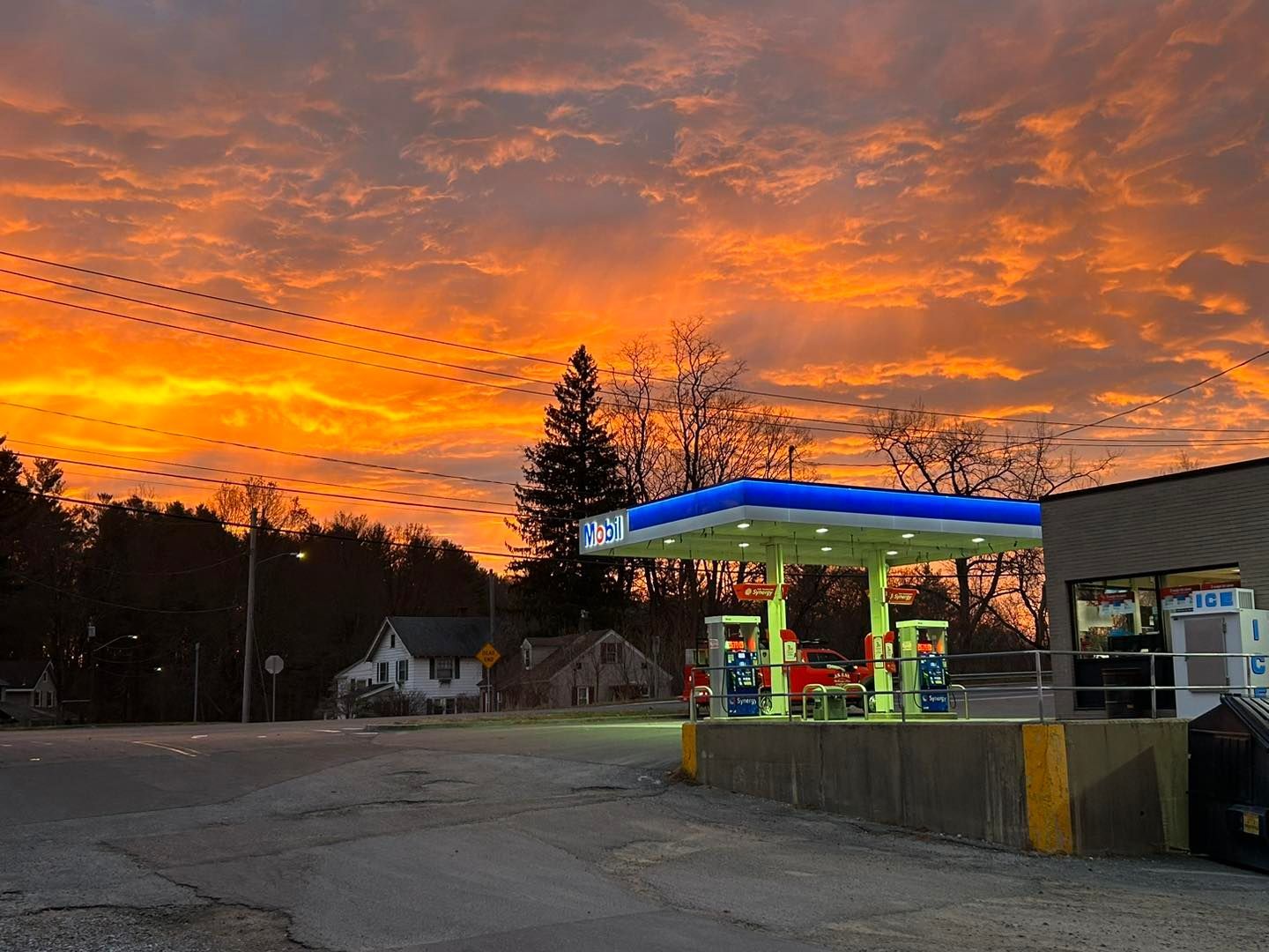 Gas station under a vibrant orange and yellow sunset.