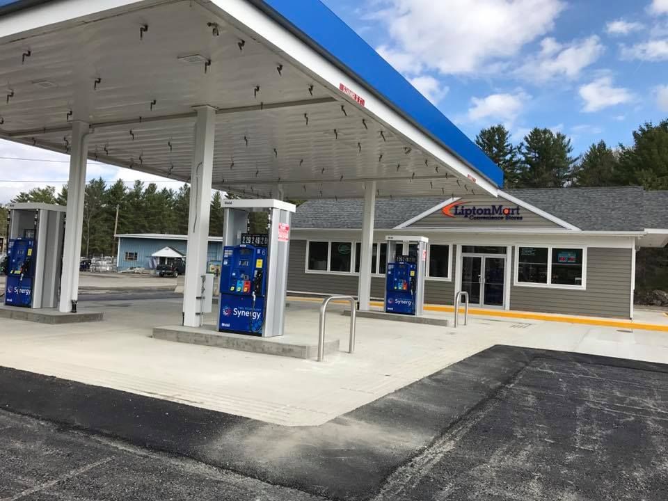 Gas station with blue canopy, pumps, and convenience store with UpNorth Mart sign.