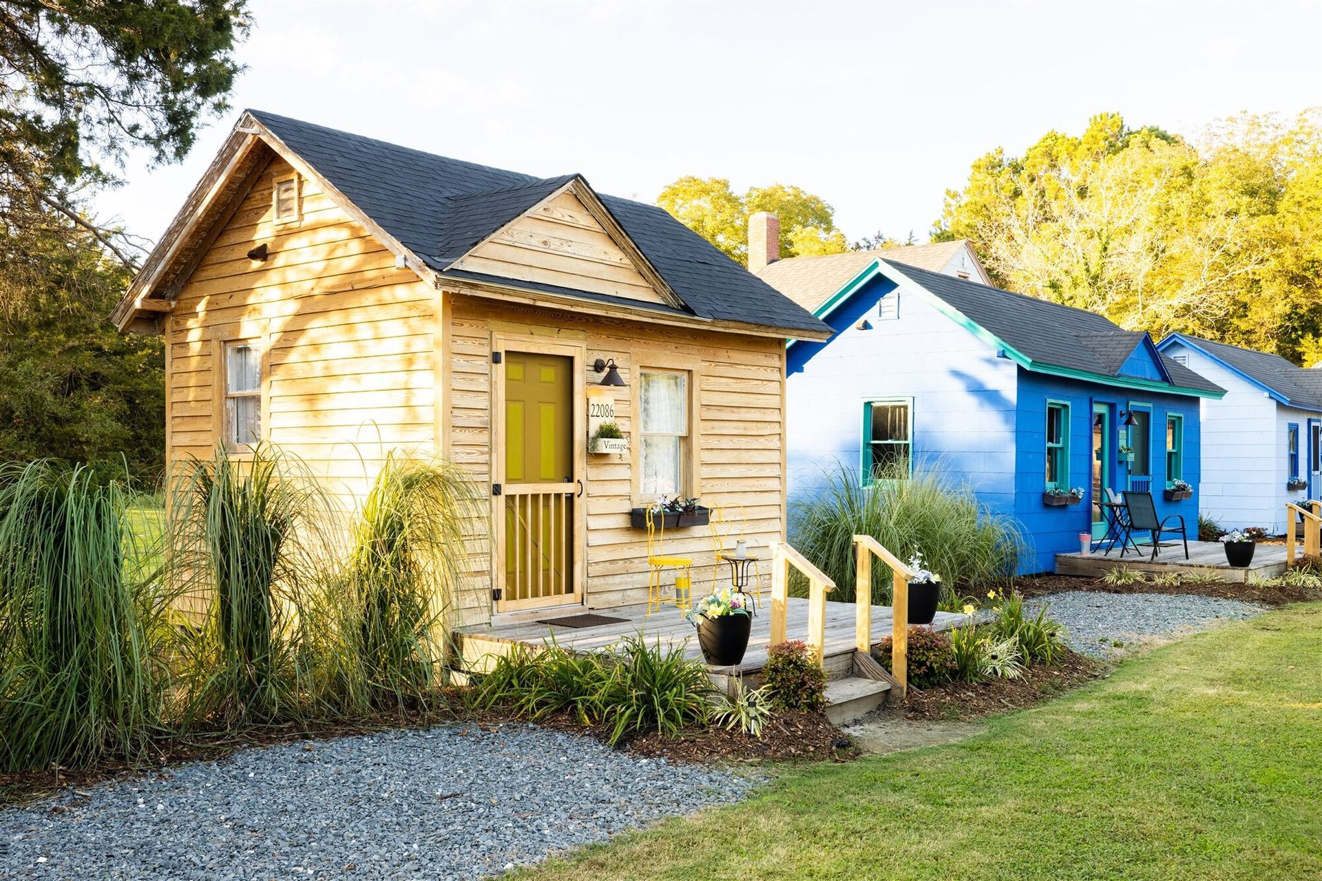 a row of colorful houses are sitting next to each other on a lush green field .