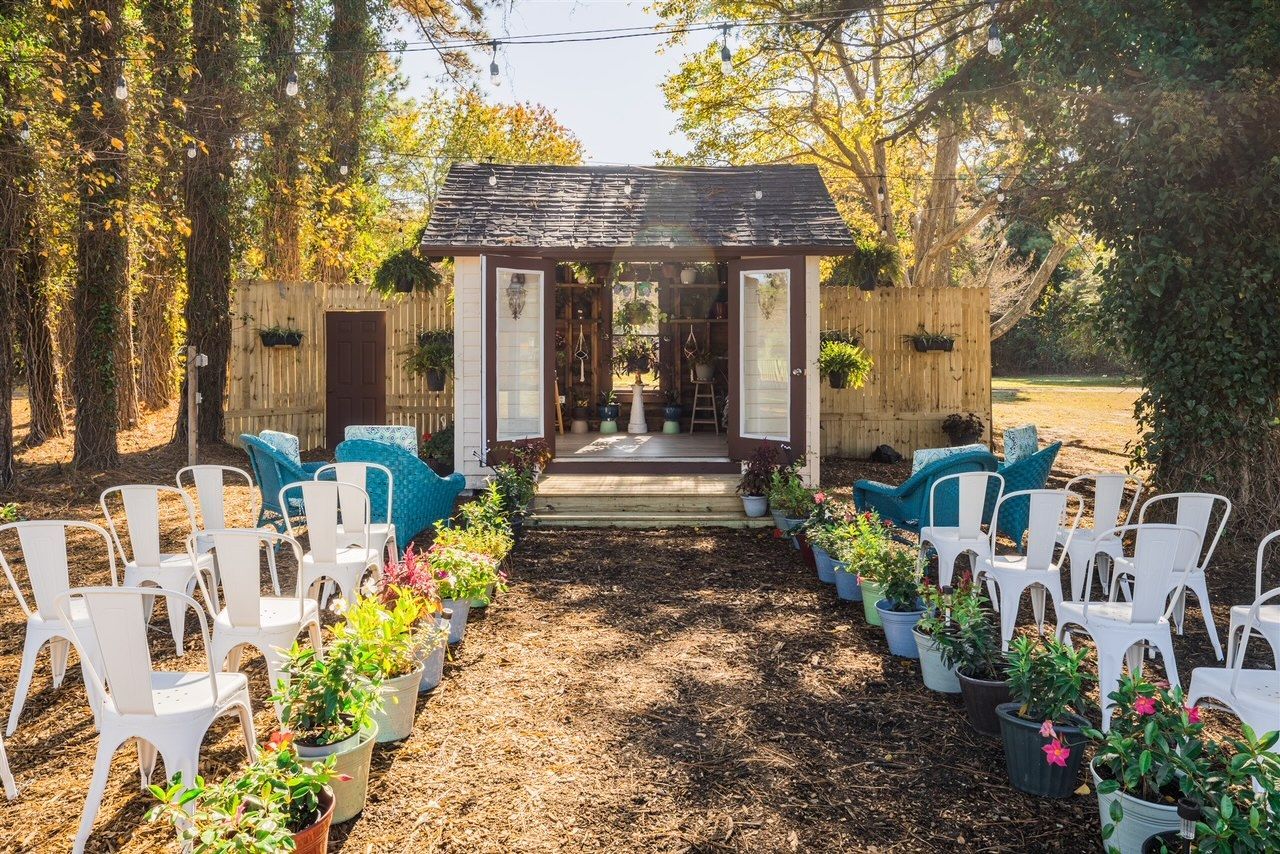 a row of chairs and flowers are lined up in front of a building .
