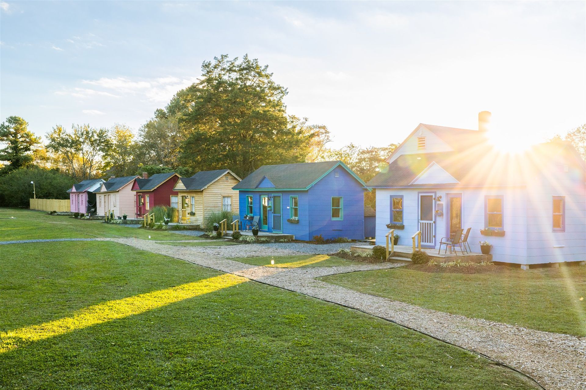 a row of colorful houses in a small town with the sun shining through the windows .