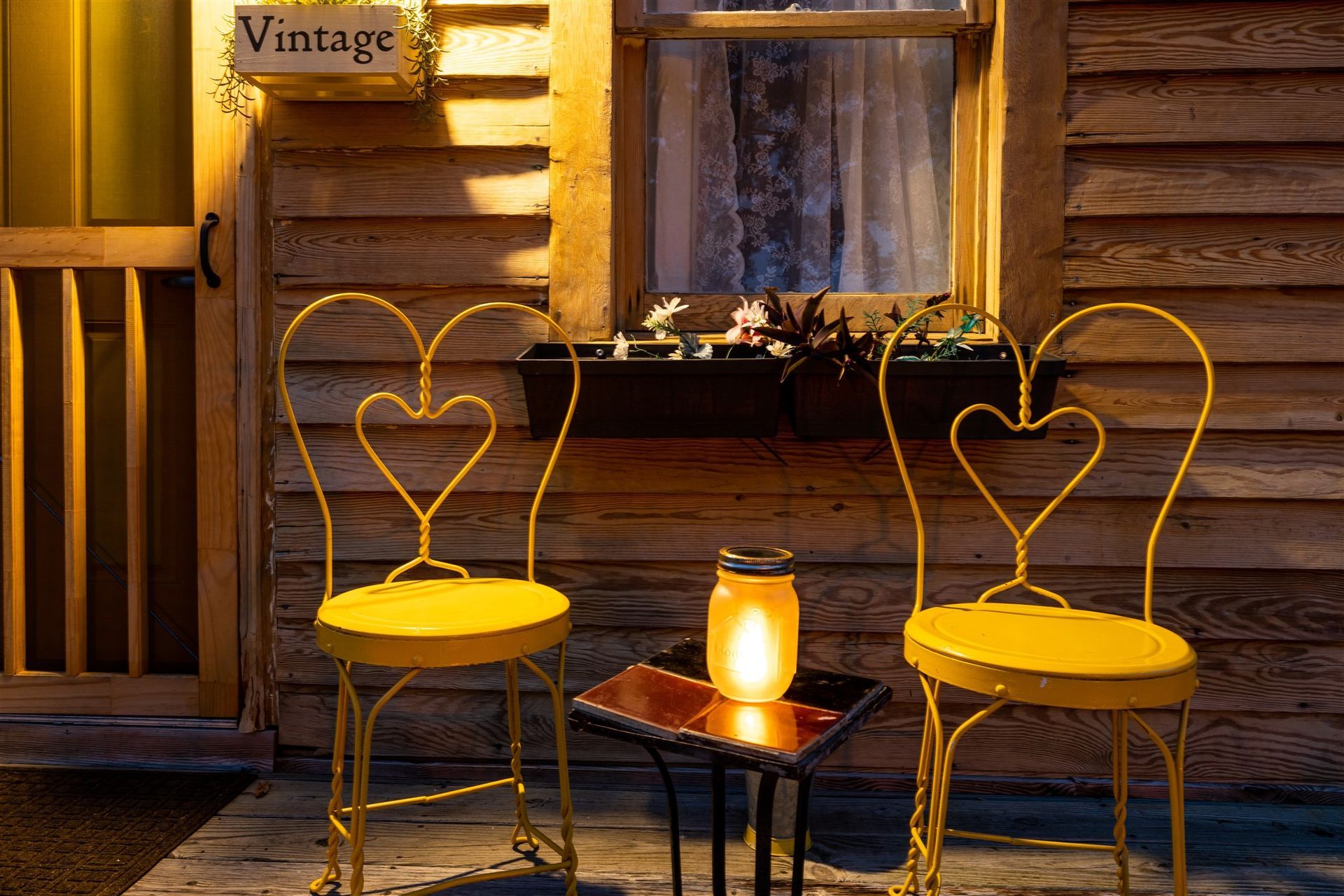 two yellow chairs are sitting on a porch in front of a wooden building .