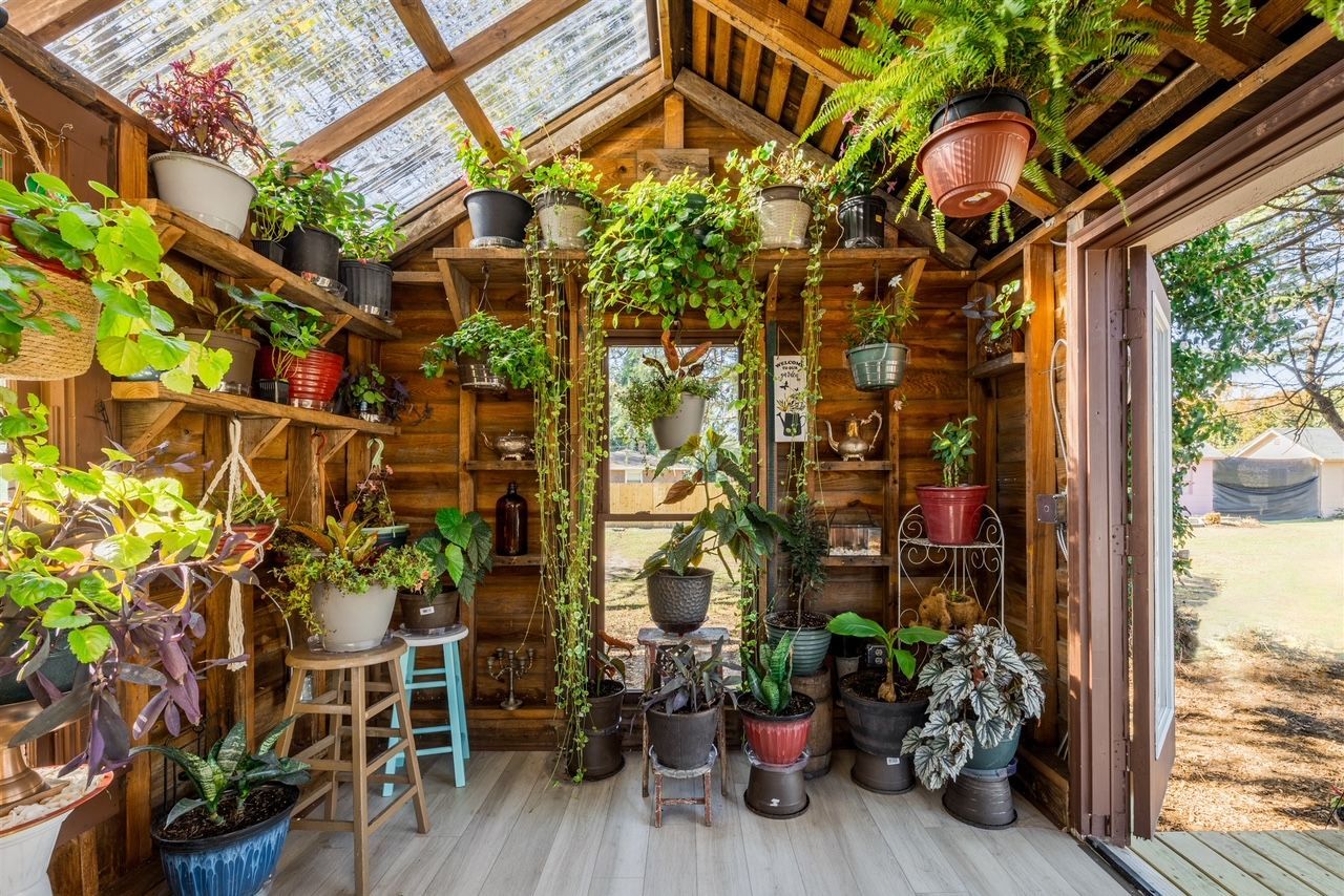 a greenhouse filled with lots of potted plants .
