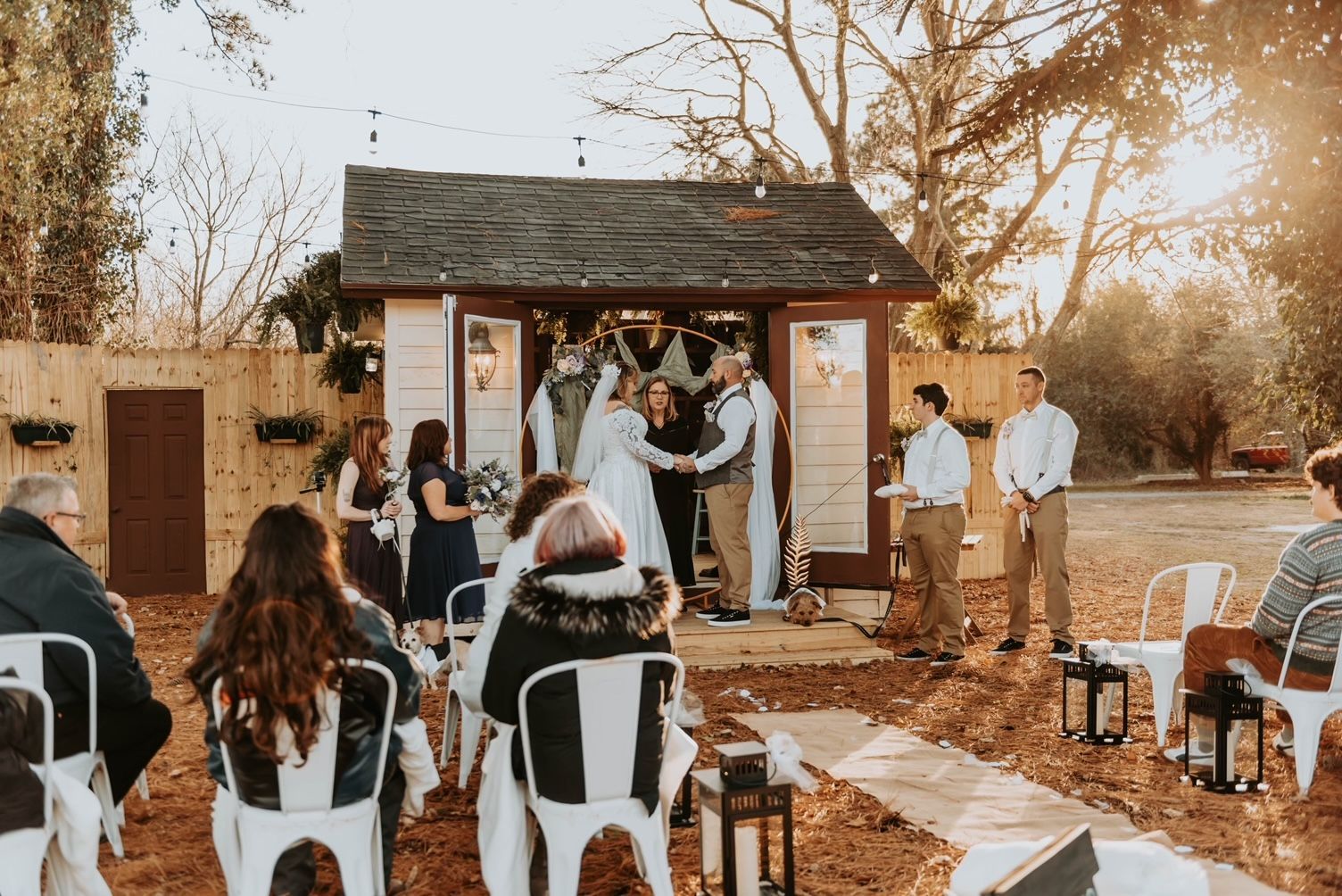 a group of people are sitting in chairs watching a wedding ceremony .