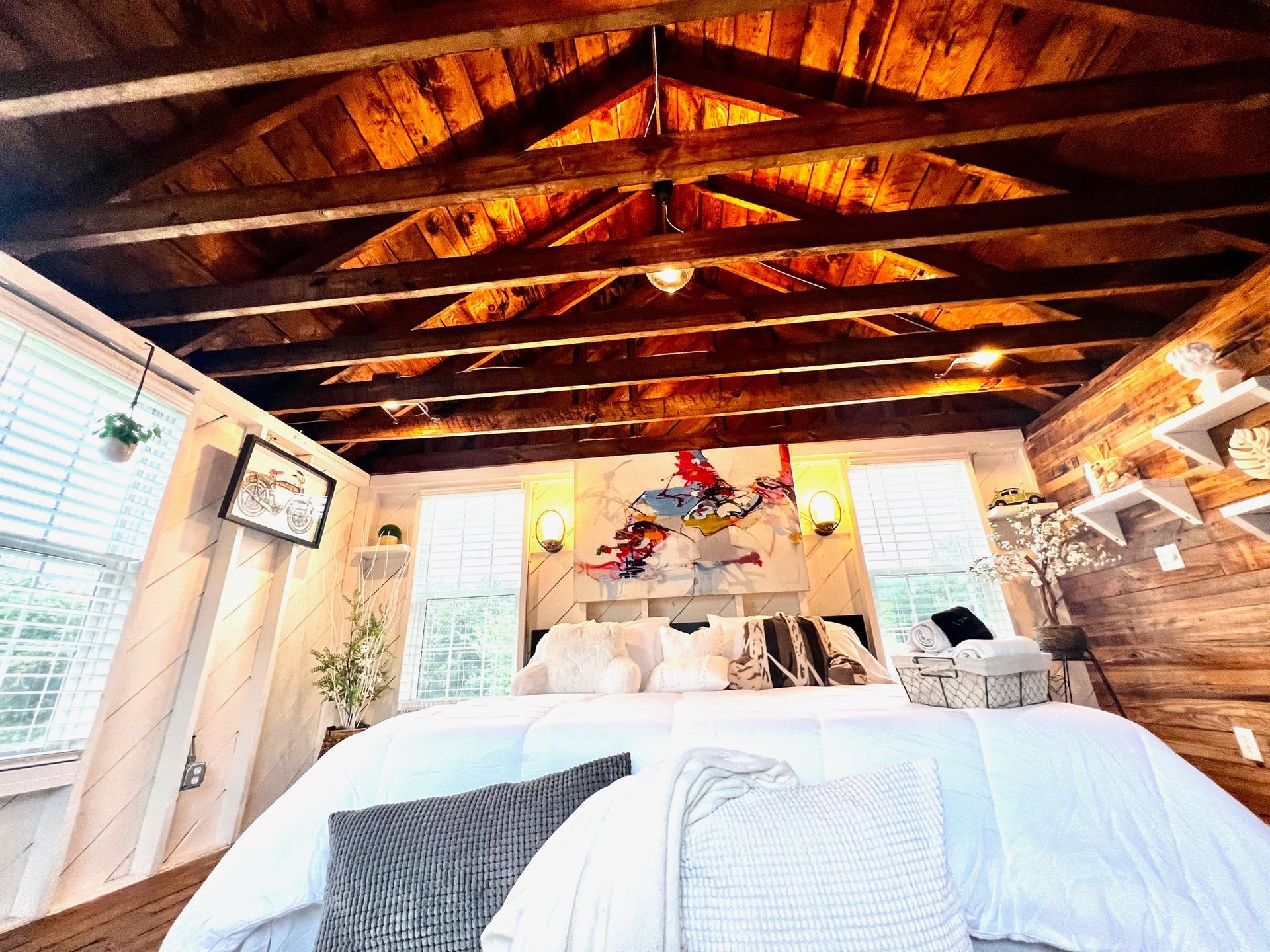 a bedroom with a large bed and a wooden ceiling .
