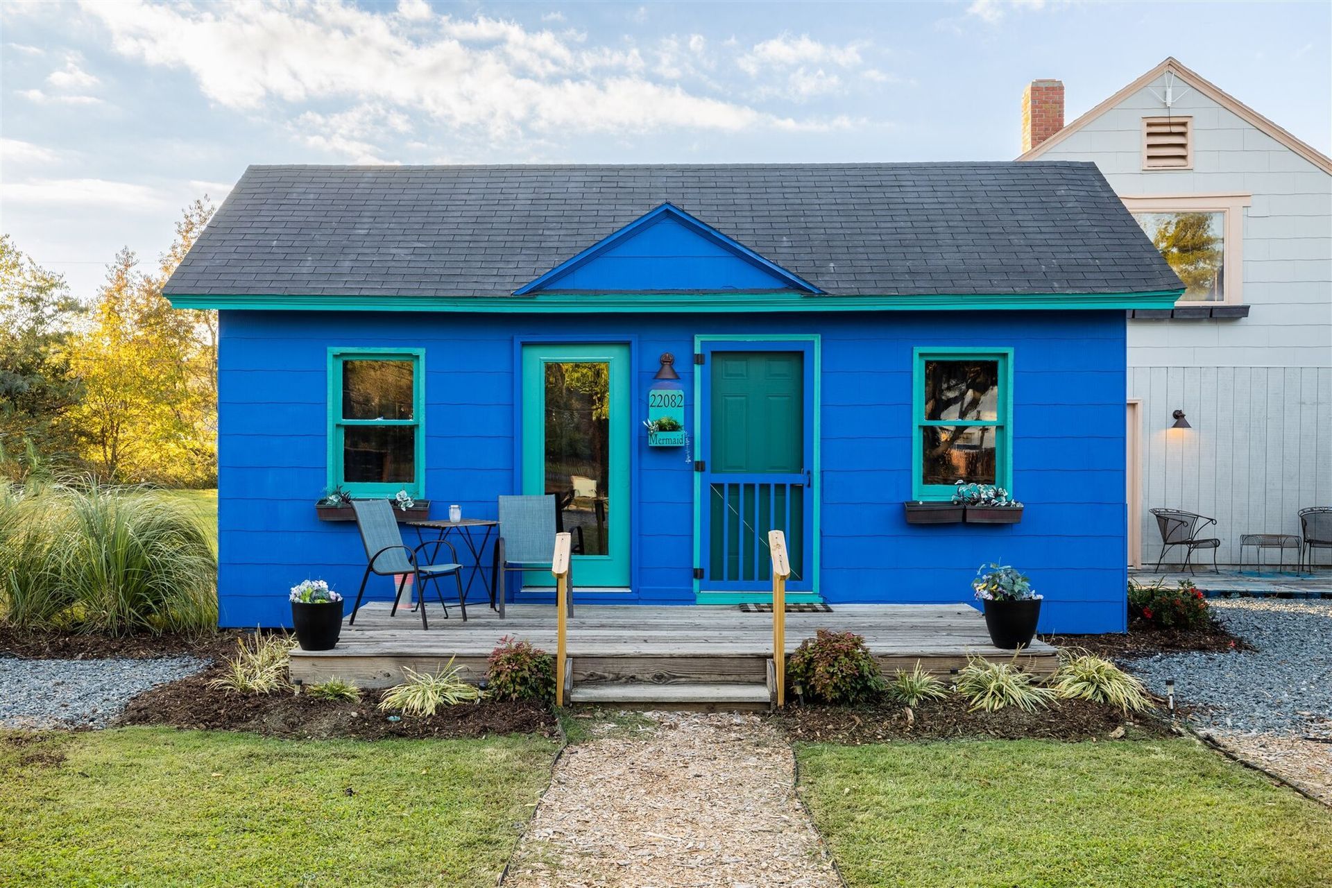 a small blue house with green trim and a porch .