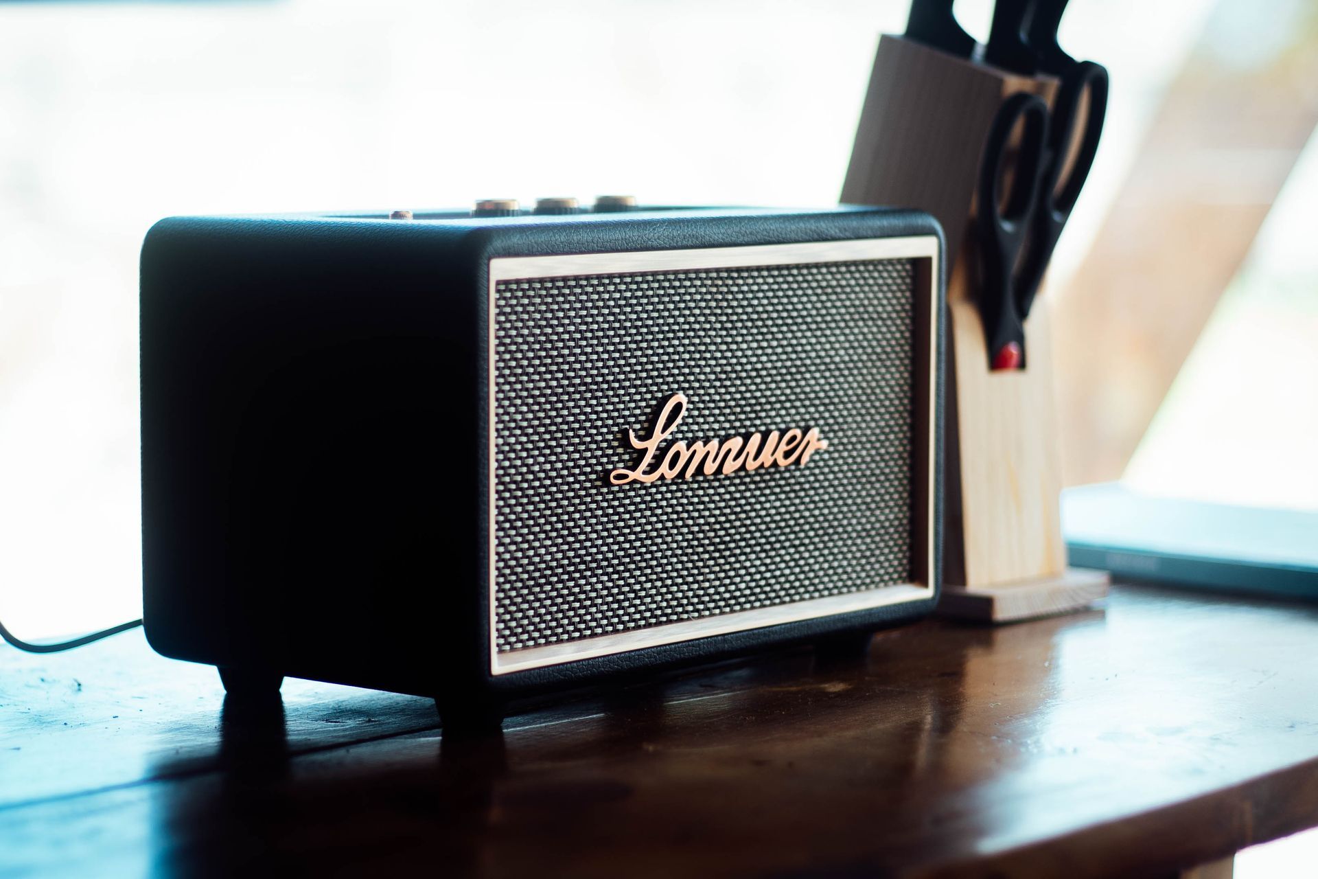 A black marshall speaker on a wooden table.