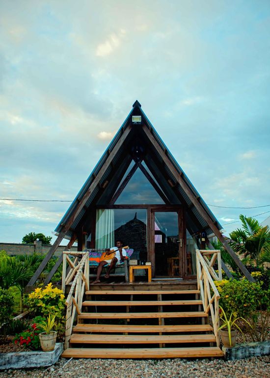 A small wooden house with a blue roof and stairs.