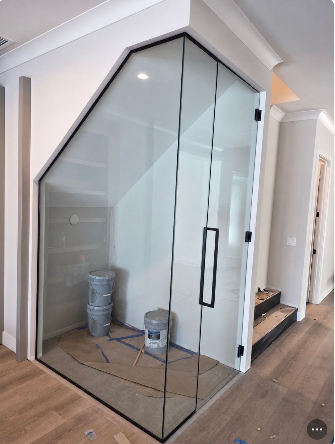 Clear acrylic wine rack in a modern room with a wood floor and white walls.