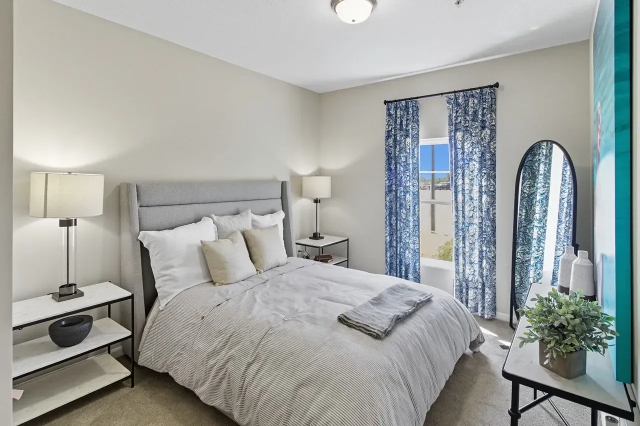 Primary bedroom with a king-size bed, nightstands, and a full-length mirror.