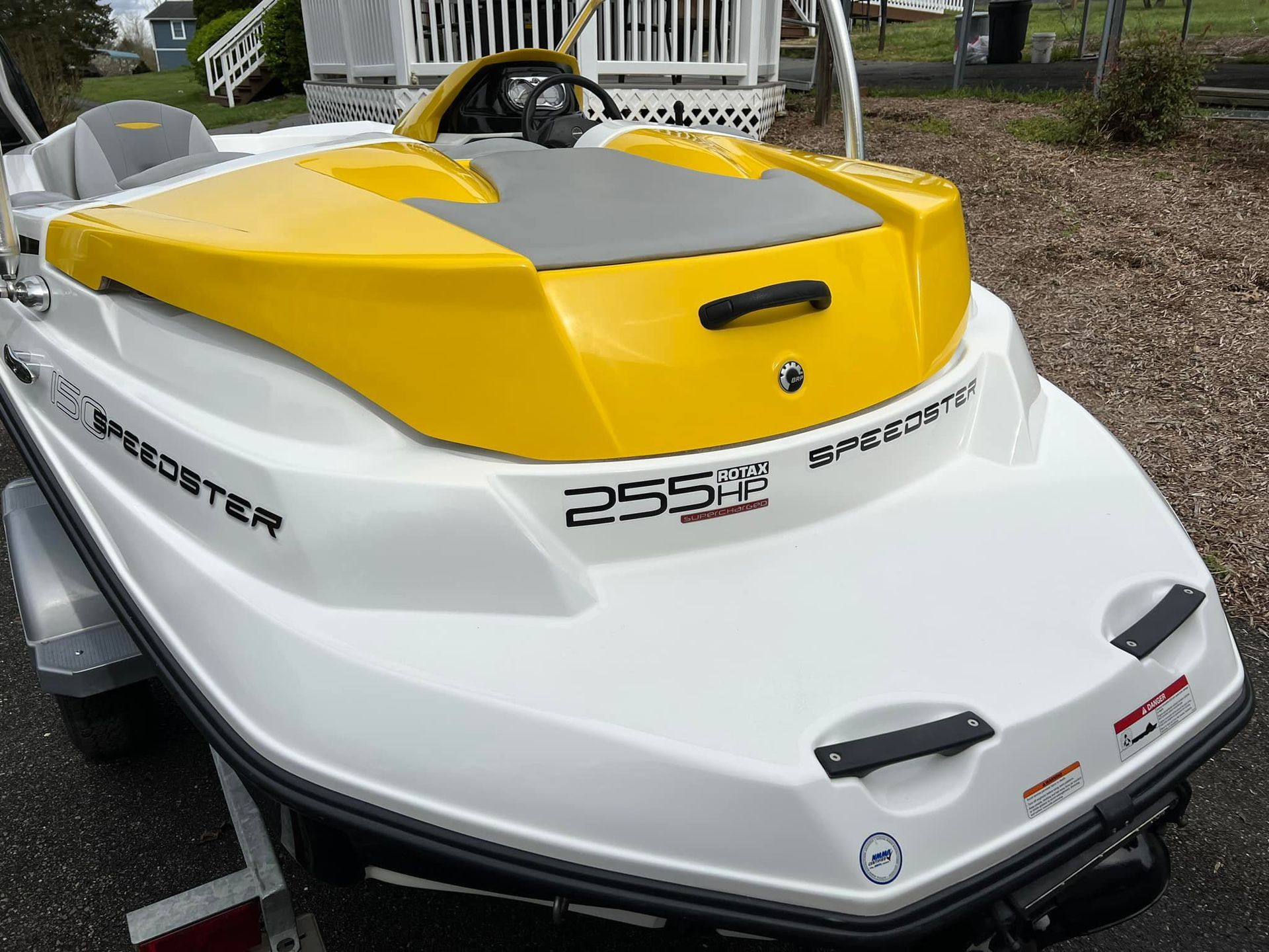 Yellow and white Sea-Doo jet ski parked outdoors on a trailer