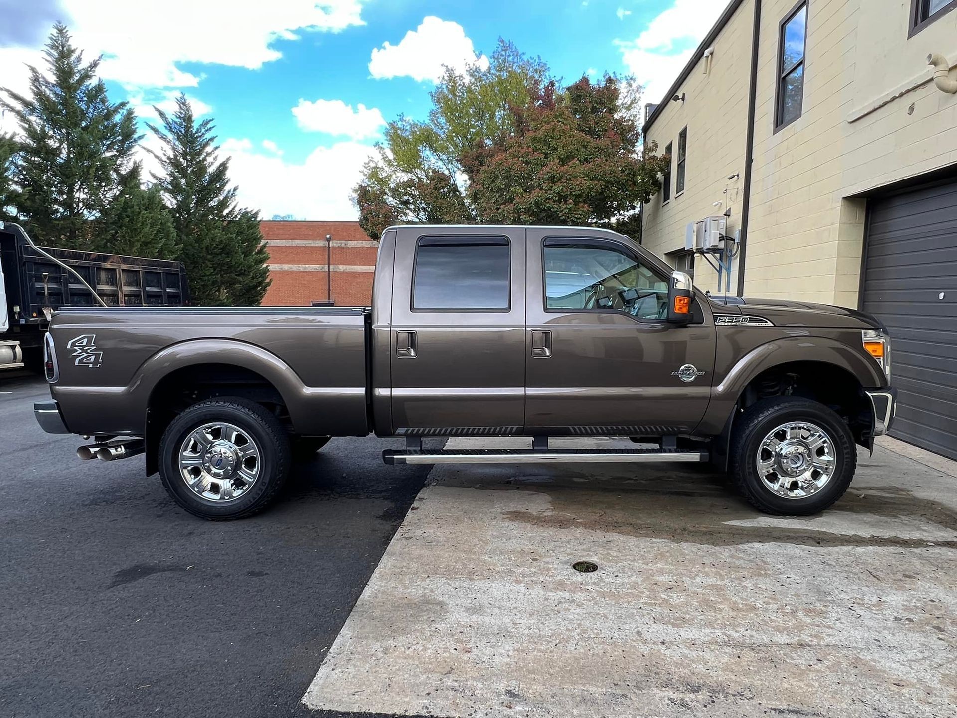 Brown pickup truck parked outside a building on a paved lot.