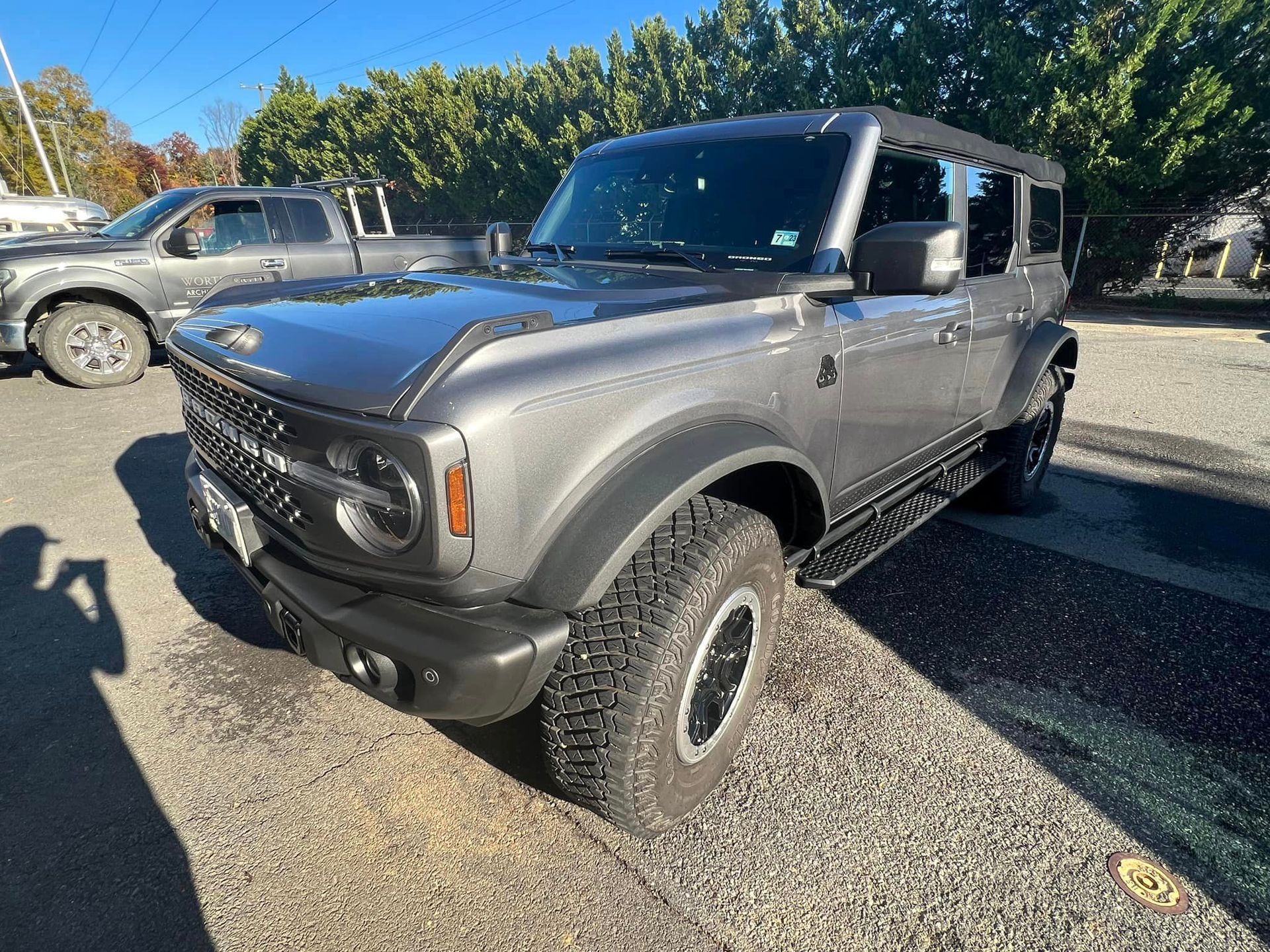 Gray off-road SUV parked on gravel in a lot, shown from the front-left side.