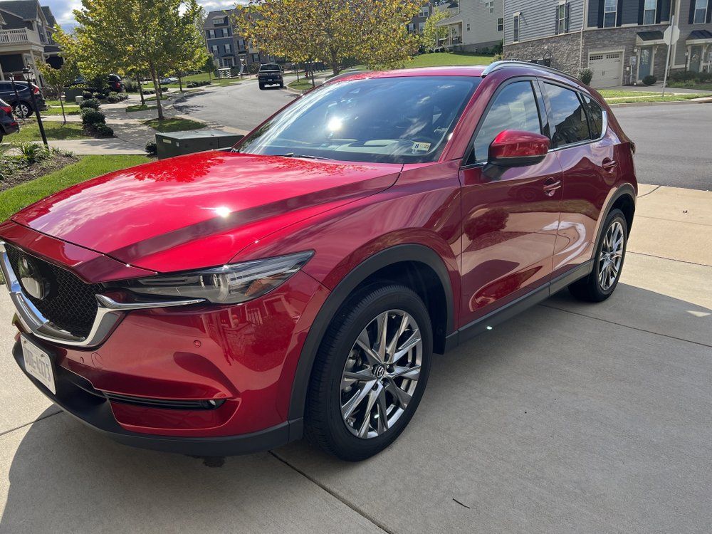 Red compact SUV parked on a suburban street, shown in three-quarter front view.