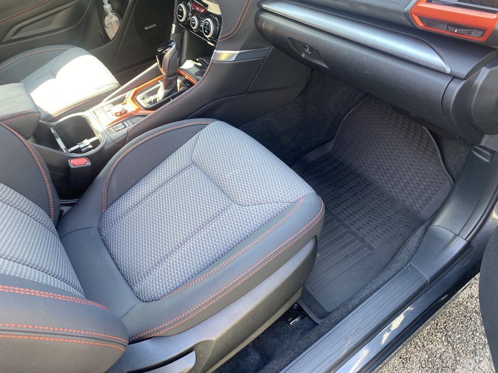Car interior with gray seats, orange trim, and center console view from the passenger side
