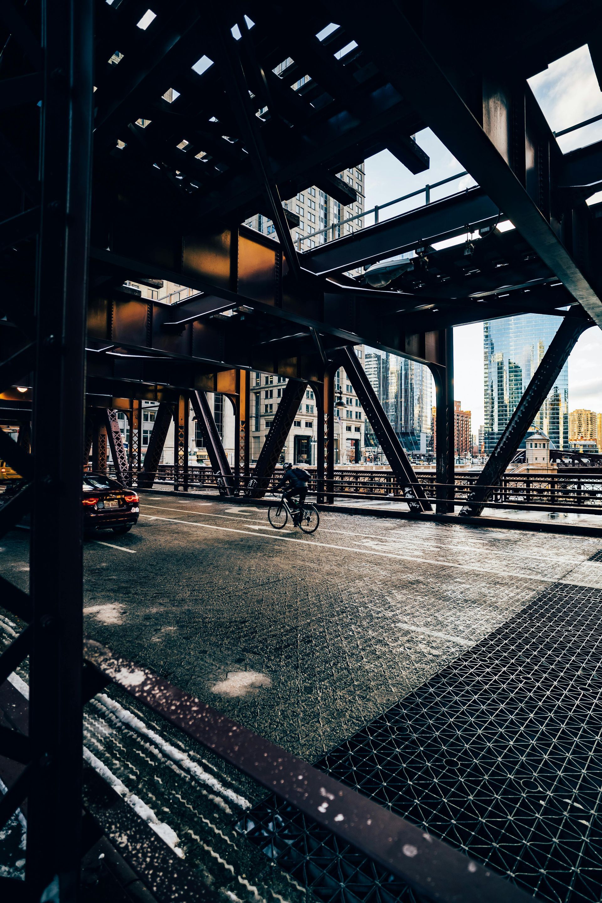 A view of a city from underneath a bridge.