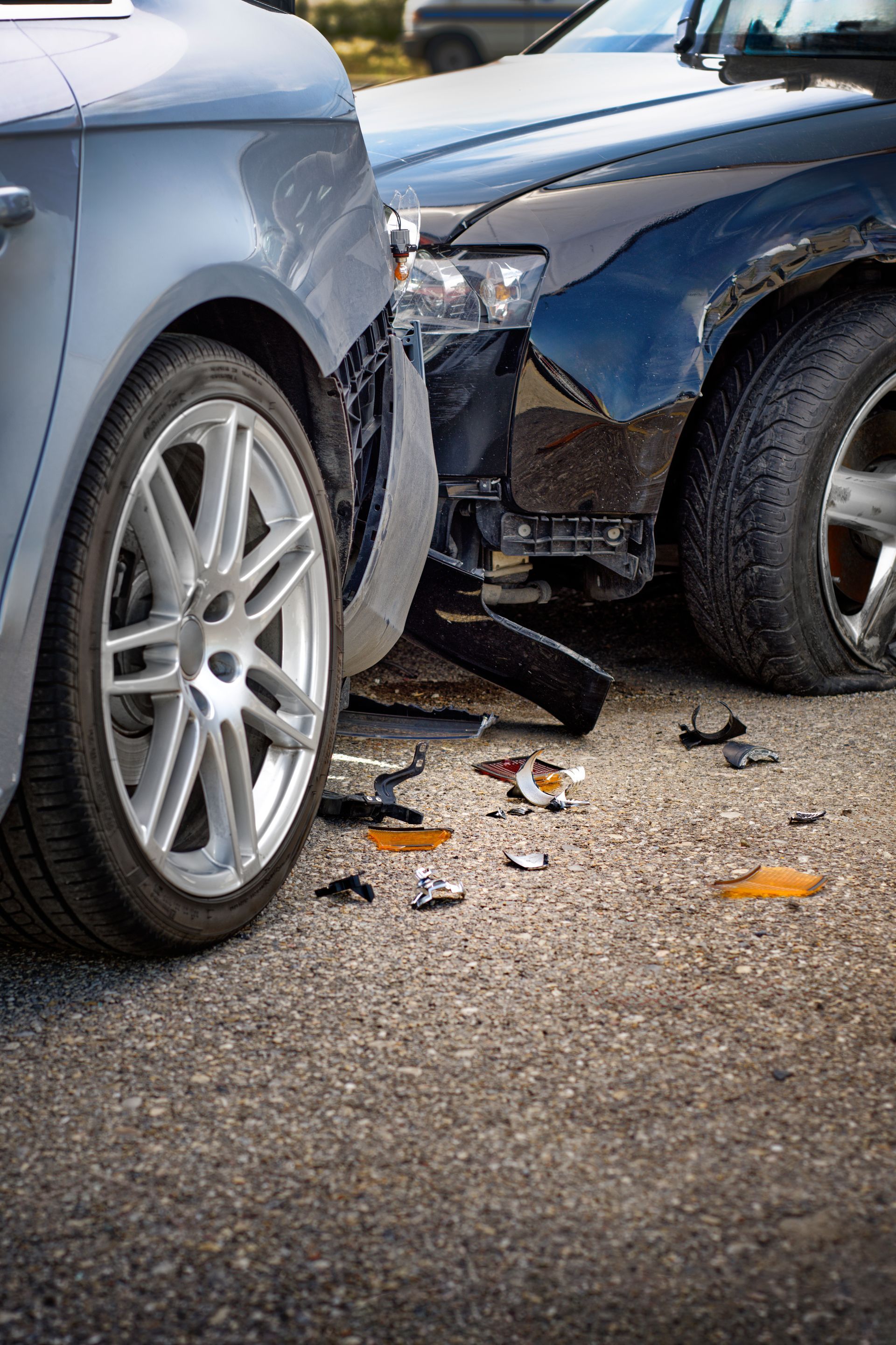 Two cars with front-end collision damage, debris scattered on the road.