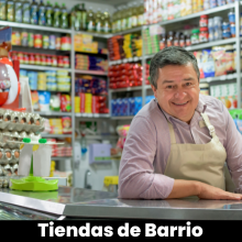 Un hombre con delantal está sentado en el mostrador de una tienda de comestibles usando Vendty Pos