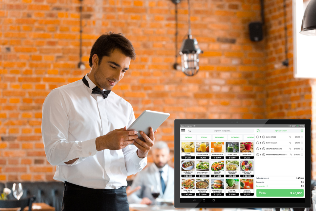 Un camarero está usando una tableta en un restaurante.