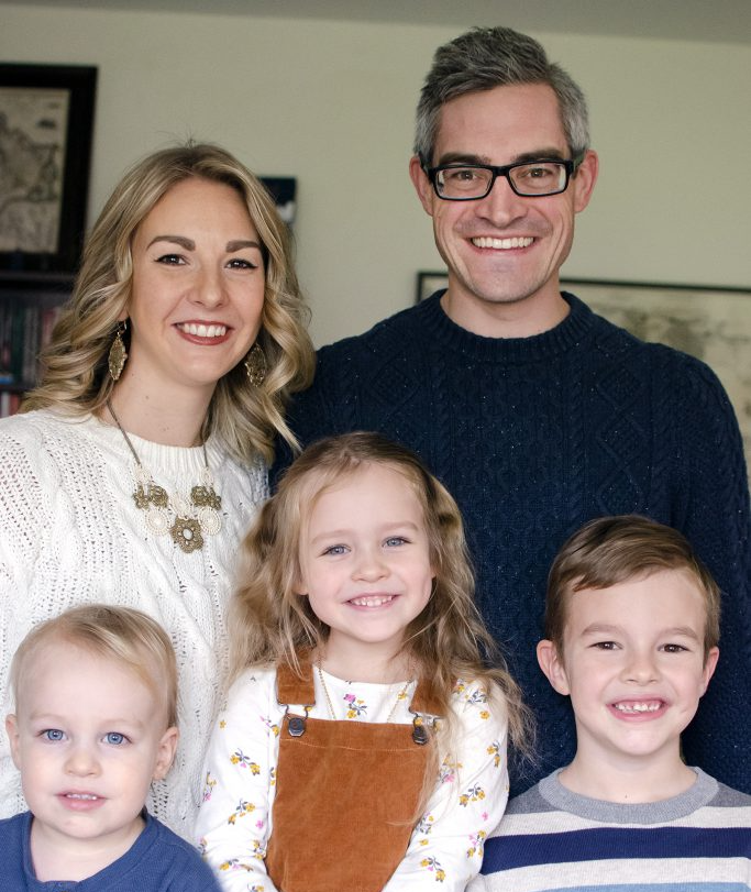 A family posing for a picture together in a living room.