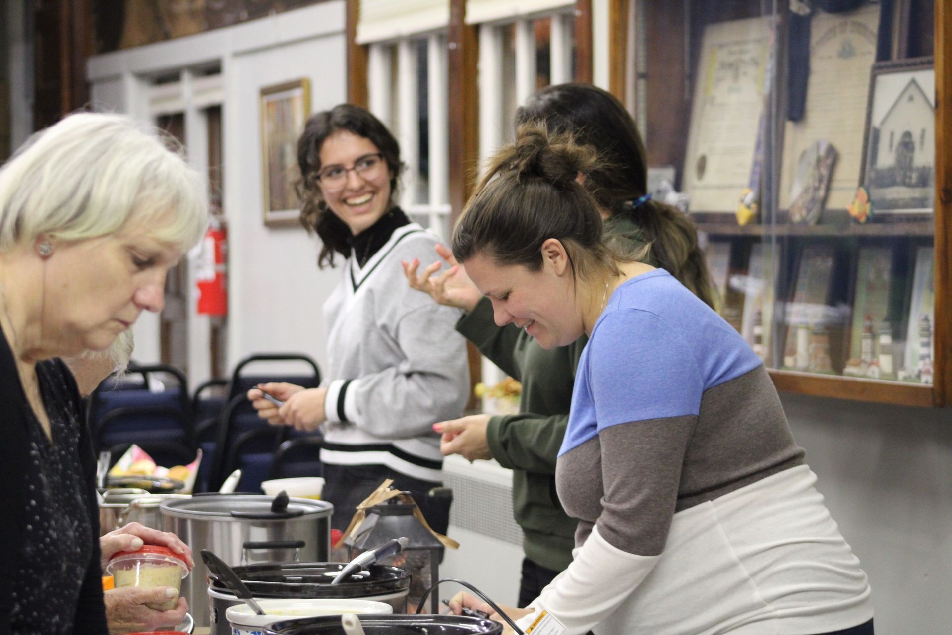 A group of women are preparing food in a kitchen.