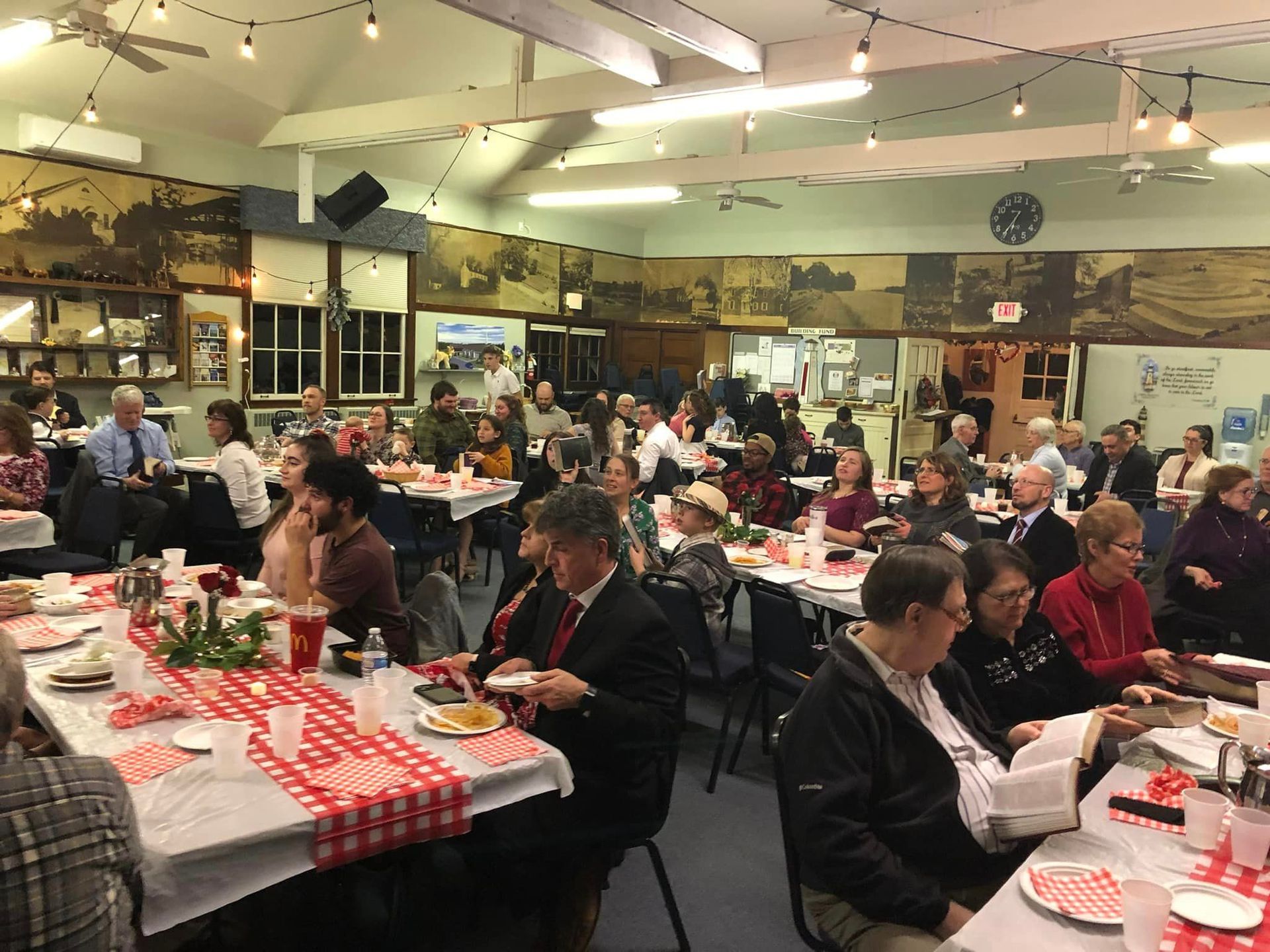 A large group of people are sitting at tables in a large room.