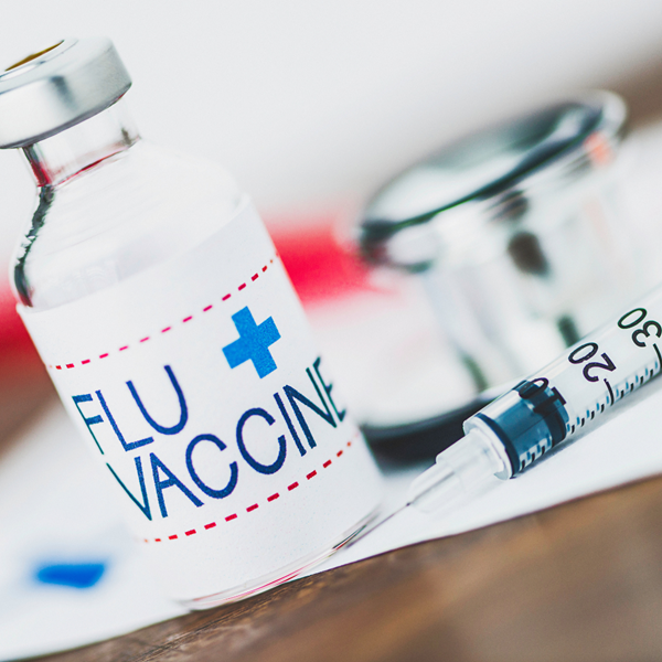 Flu vaccine vial and syringe on a white background
