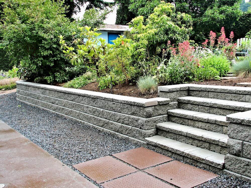 A Stone Wall with Stairs Leading up To It in A Garden — D-Scapes Landscaping Services Pty Ltd in Forster, NSW