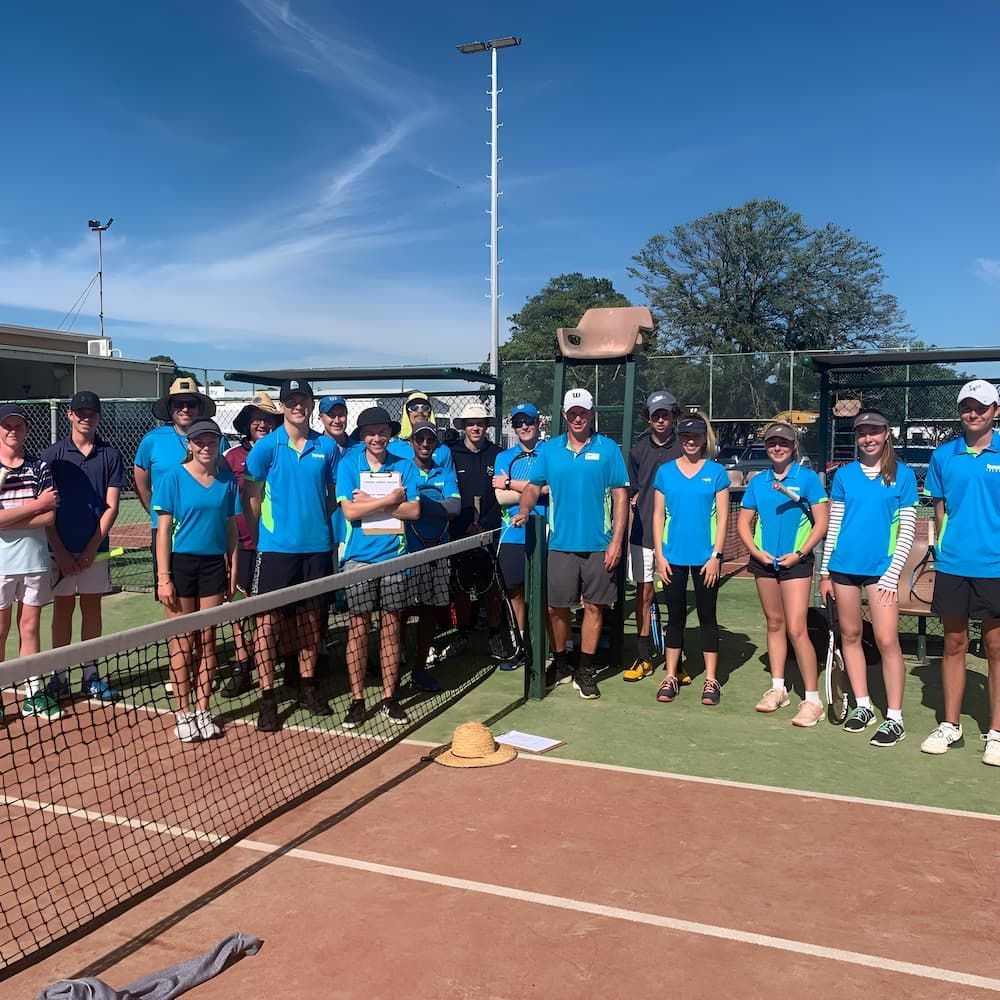 A Group of People Are Posing for a Picture on a Tennis Court — Topspin Tennis Newcastle in Lambton, NSW