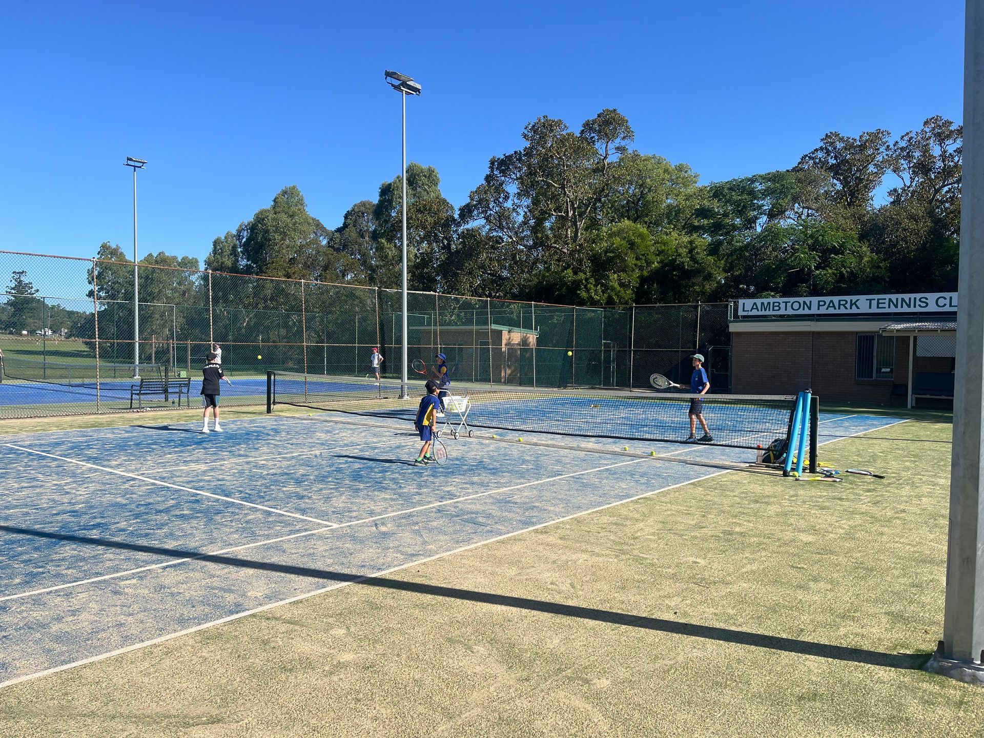 Tennis Players on a Blue Court at the Lambeth Park Tennis Club — Topspin Tennis Newcastle in Lambton, NSW