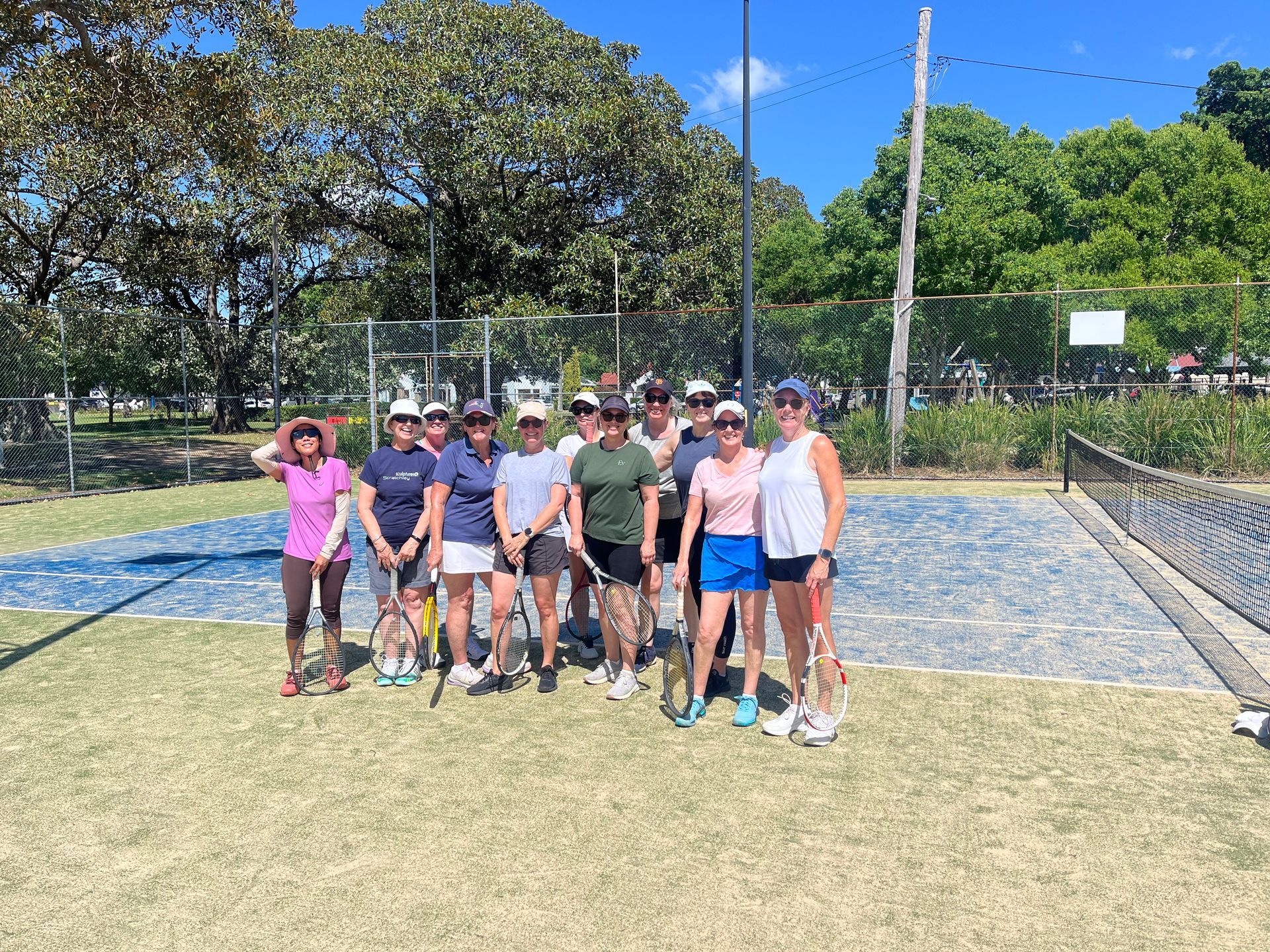 Group of Tennis Players Pose on a Blue Court — Topspin Tennis Newcastle in Lambton, NSW
