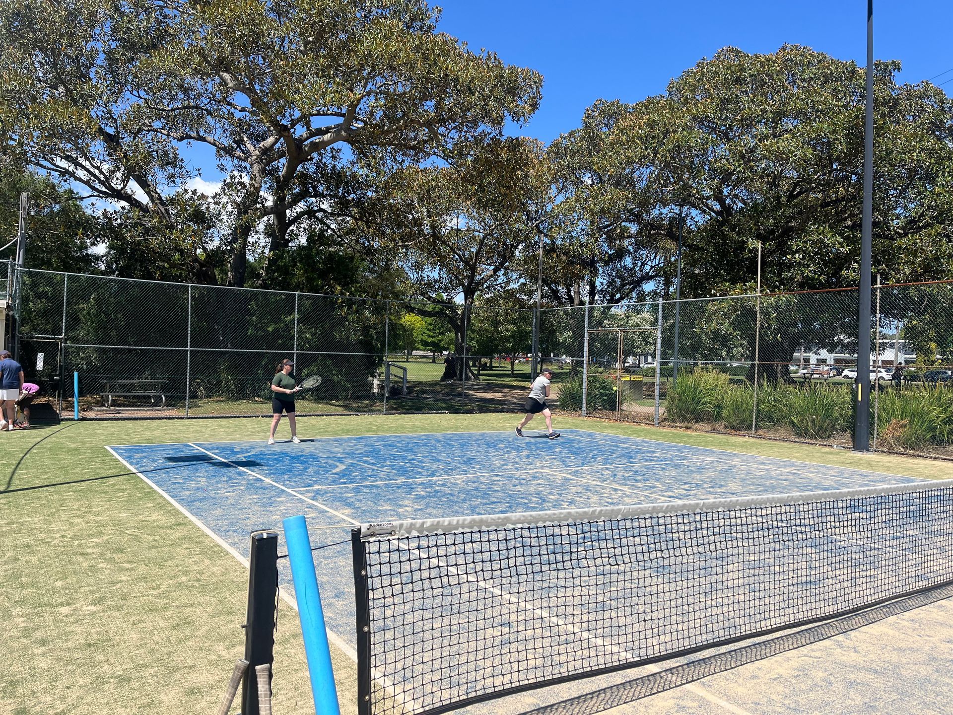 Two People Playing Tennis on a Blue Court — Topspin Tennis Newcastle in Lambton, NSW
