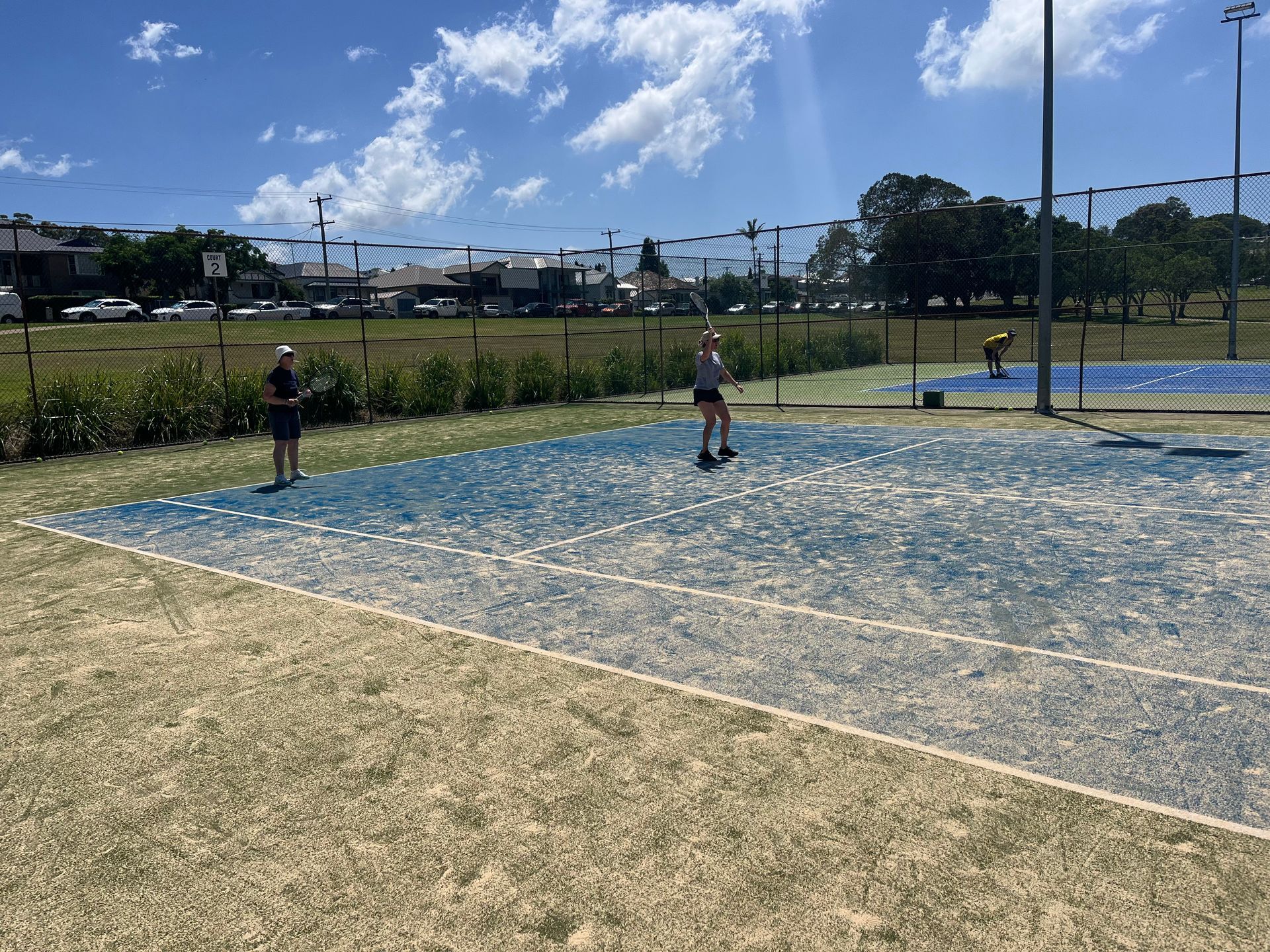 Three People Playing on a Blue and Beige Sports Court Under a Sunny Sky — Topspin Tennis Newcastle in Lambton, NSW