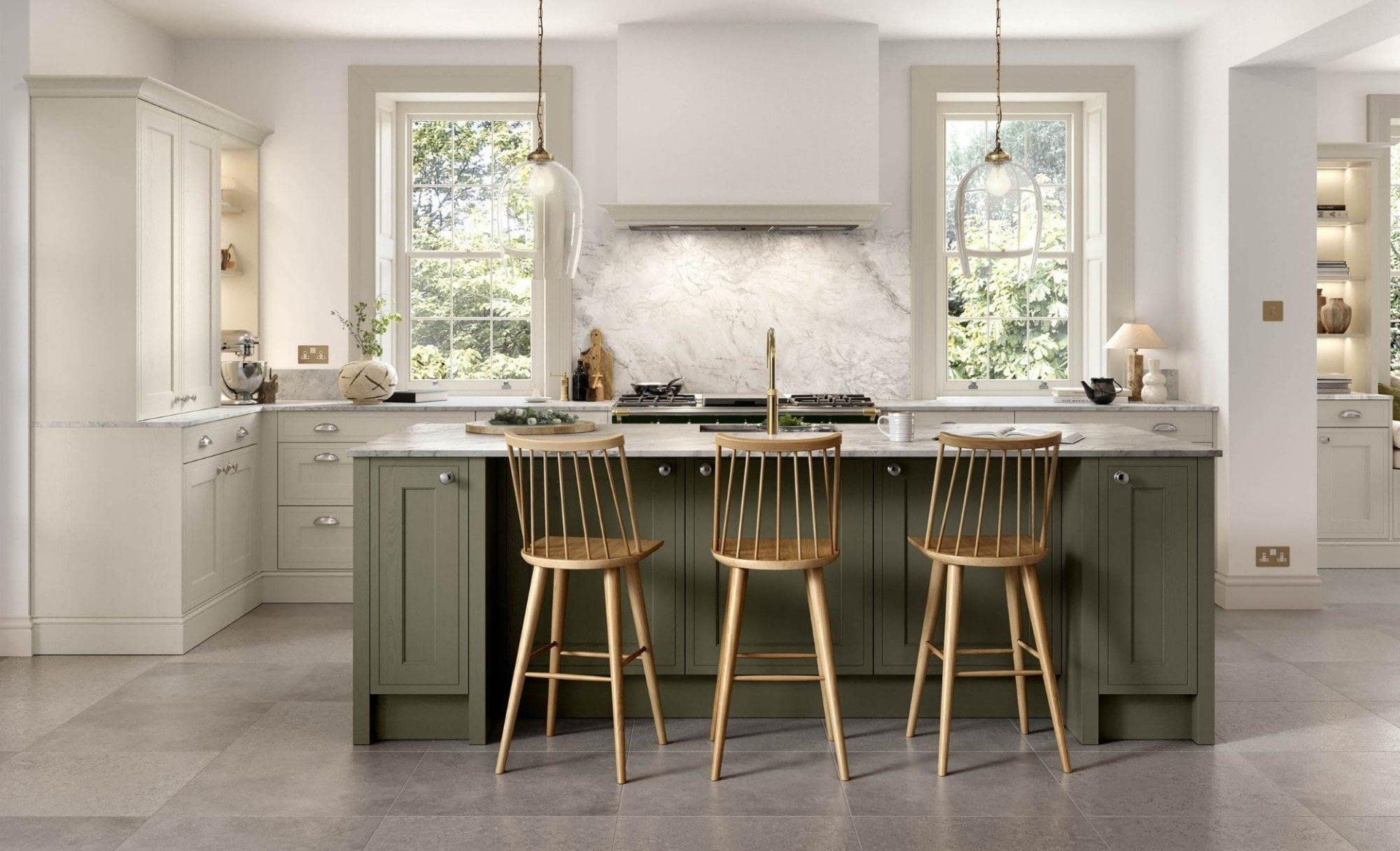 A modern kitchen featuring a dark green island with three wooden stools, light-colored cabinets, and marble backsplashes.