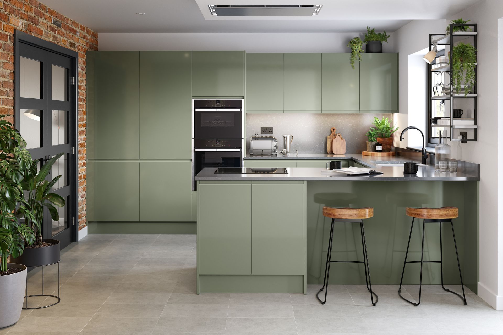 Modern kitchen with sage green cabinets, stainless steel appliances, a peninsula with two bar stools, and a brick wall.