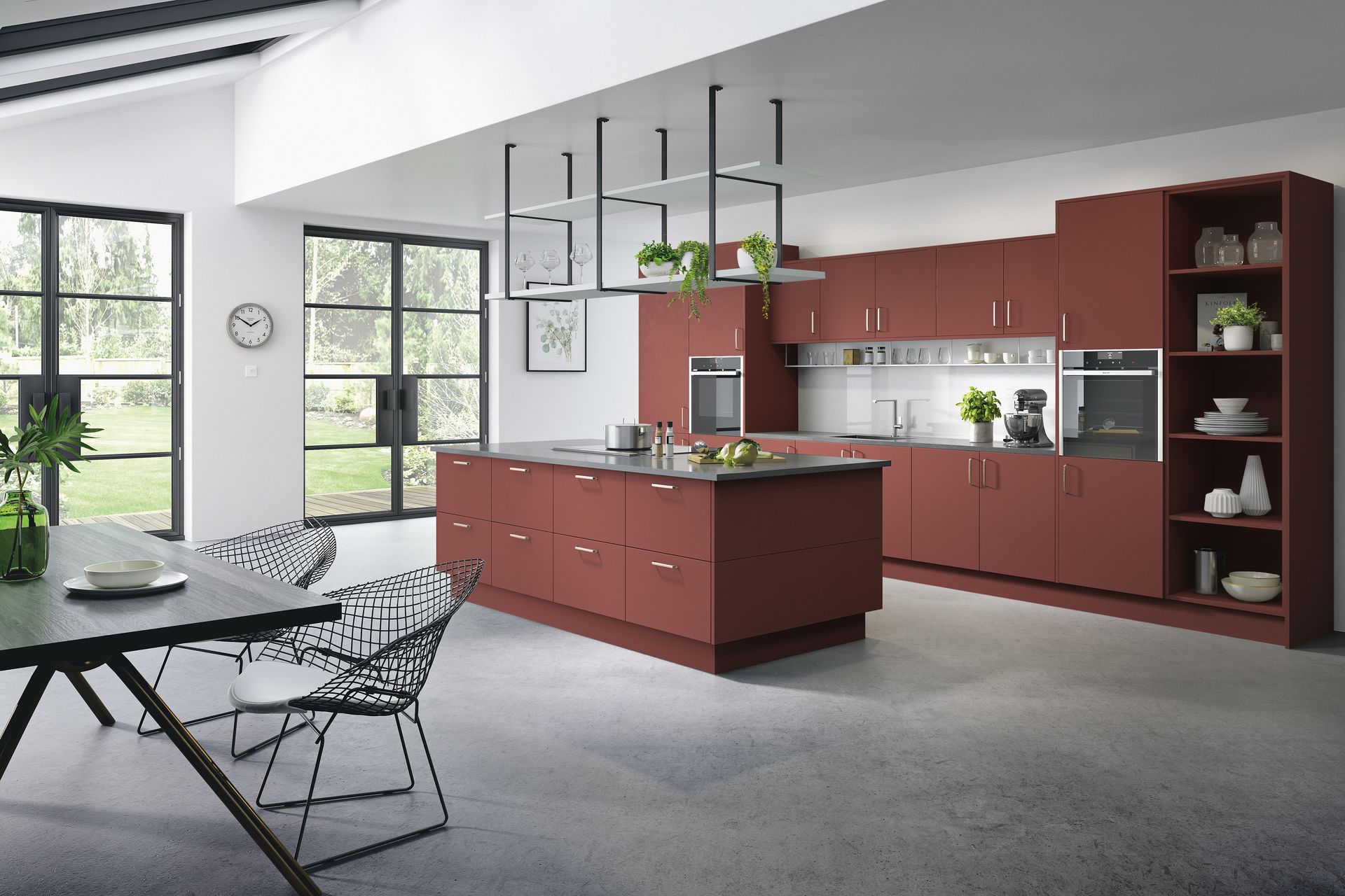 A modern kitchen featuring terracotta-colored cabinetry, a central island, and an adjacent dining area on a concrete floor.
