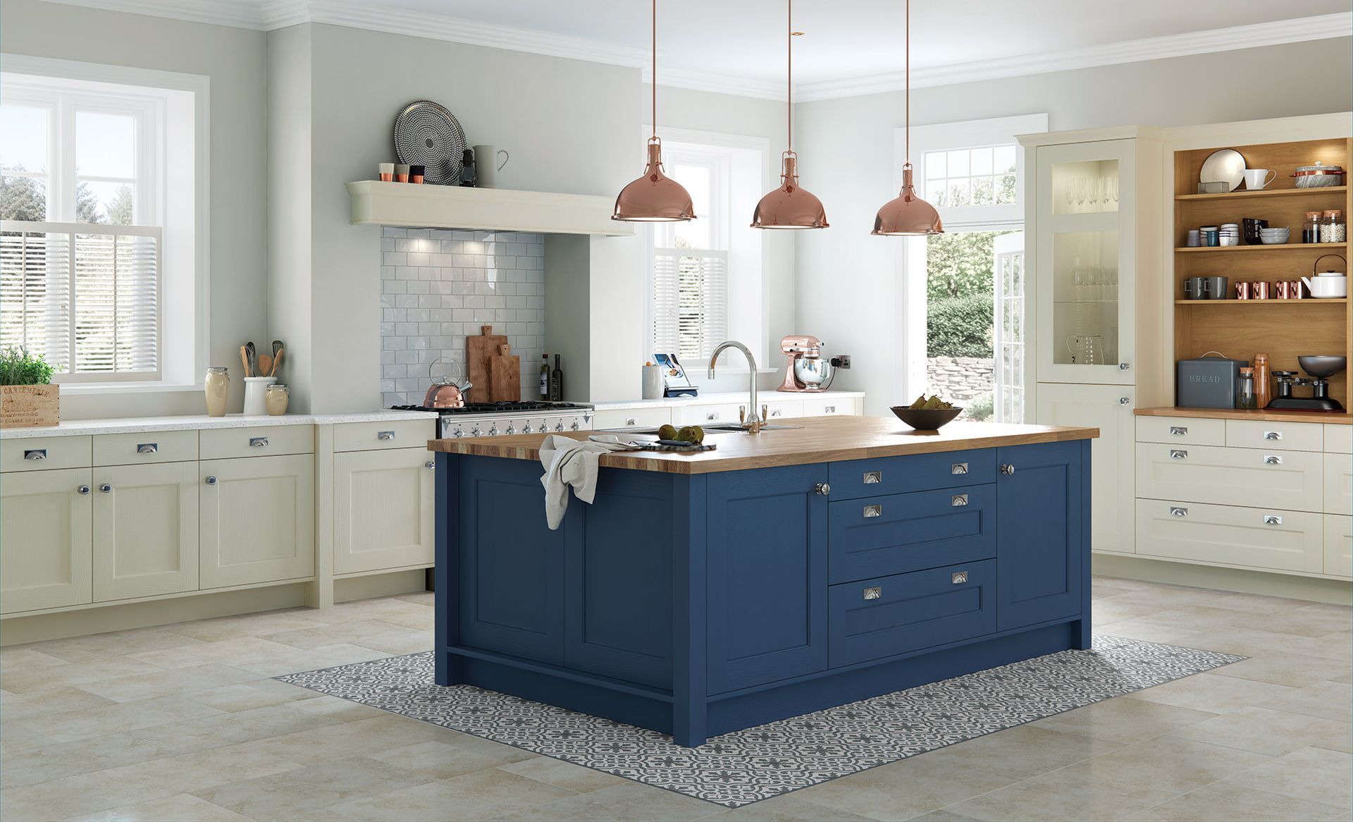 A kitchen with cream-colored cabinetry, a prominent blue central island with a wood countertop, and three copper pendants.