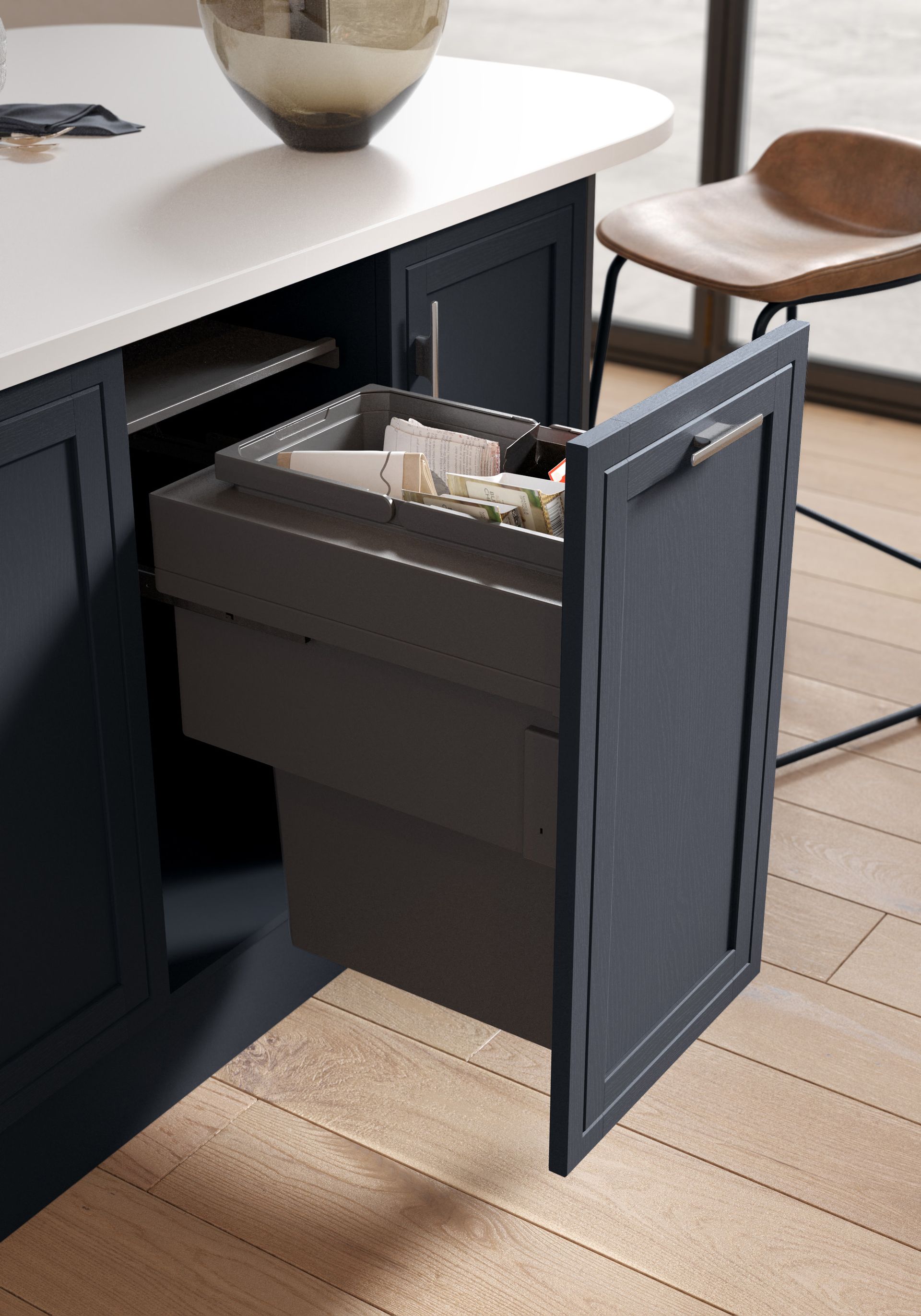 A dark blue pull-out trash and recycling bin drawer in a modern kitchen island with a light countertop.