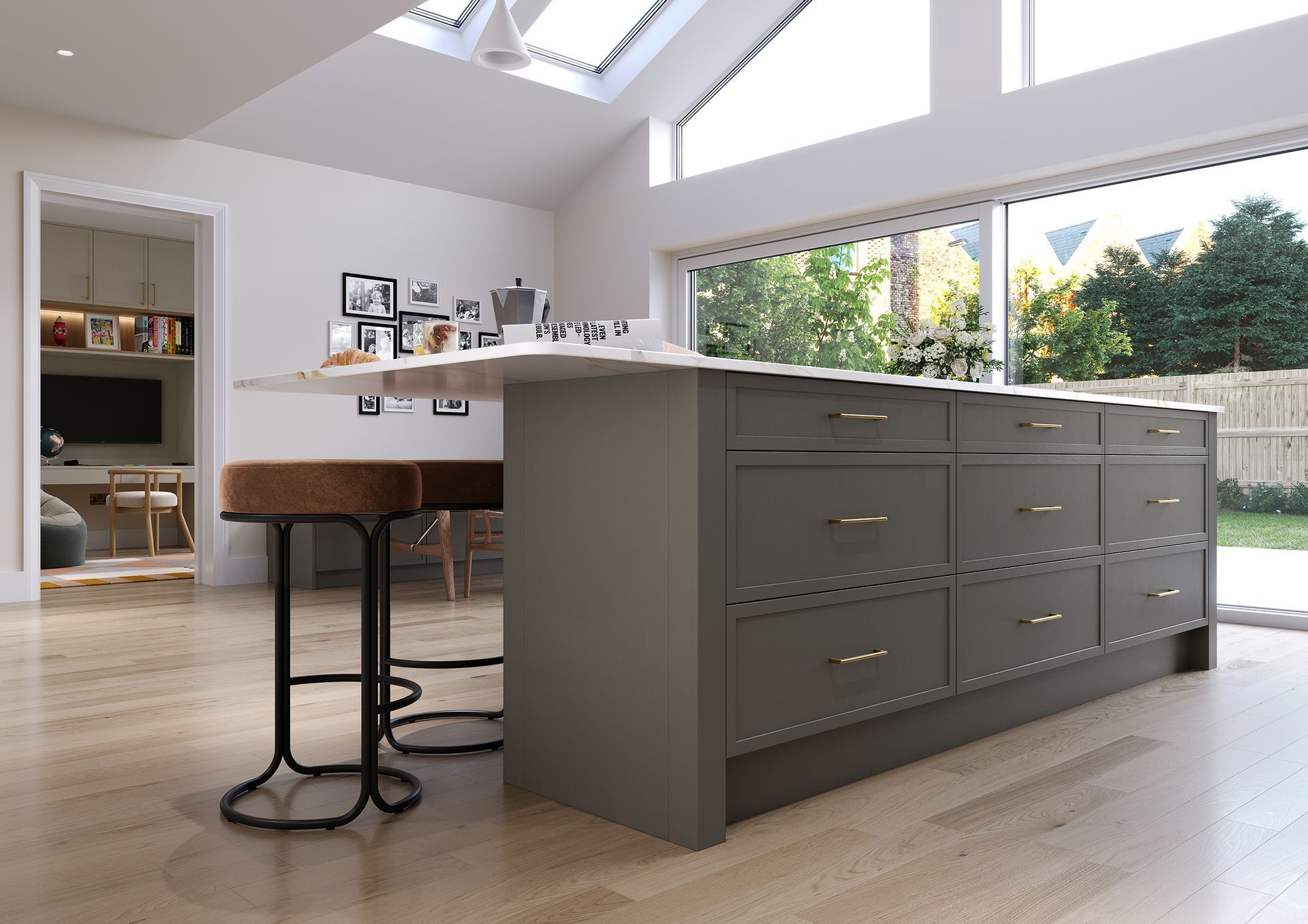 A kitchen island with gray cabinetry and brass hardware, featuring two bar stools on a light wood floor.