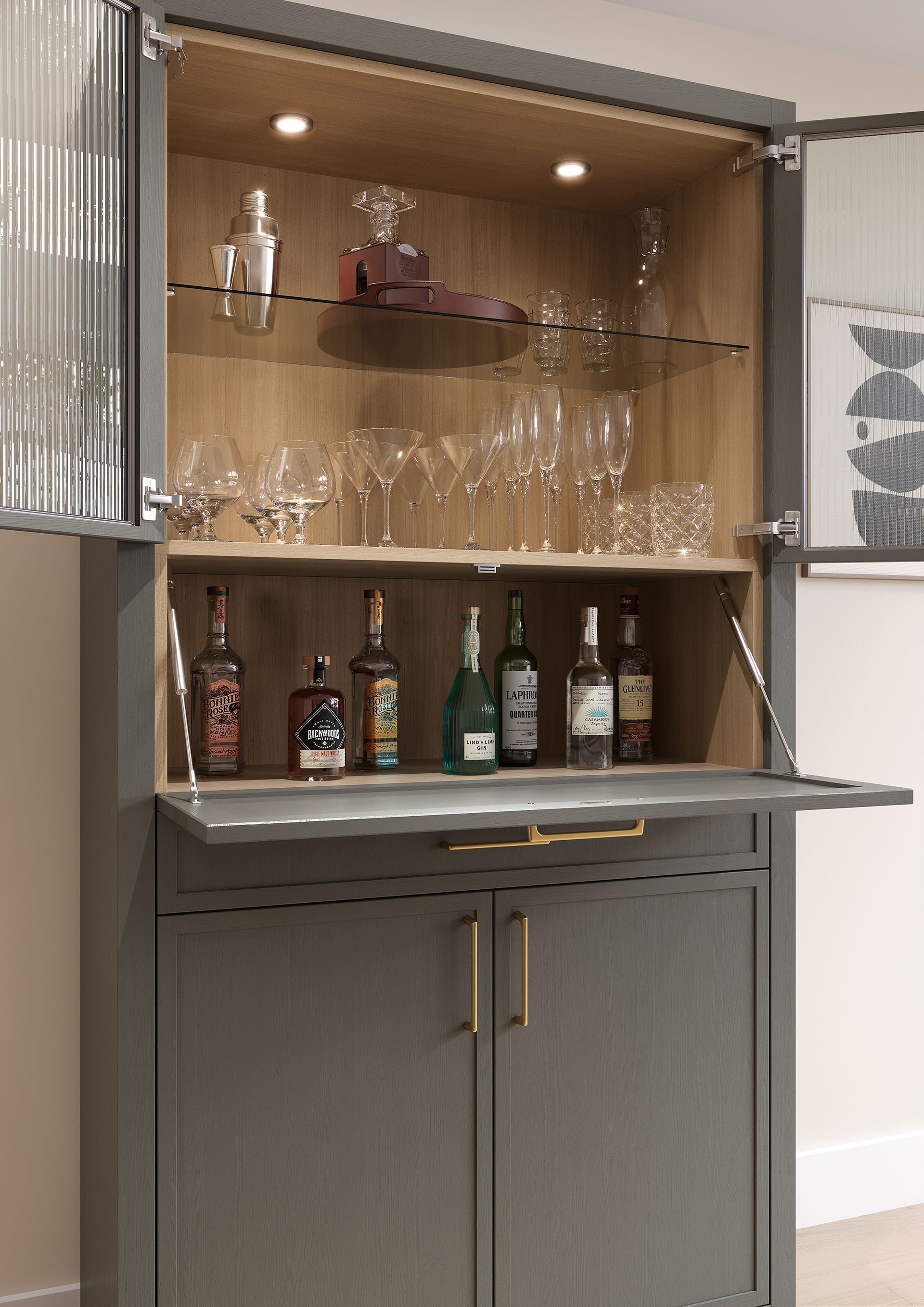 A dark gray bar cabinet with glass doors, illuminated shelves displaying glassware, and an open fold-down prep shelf.