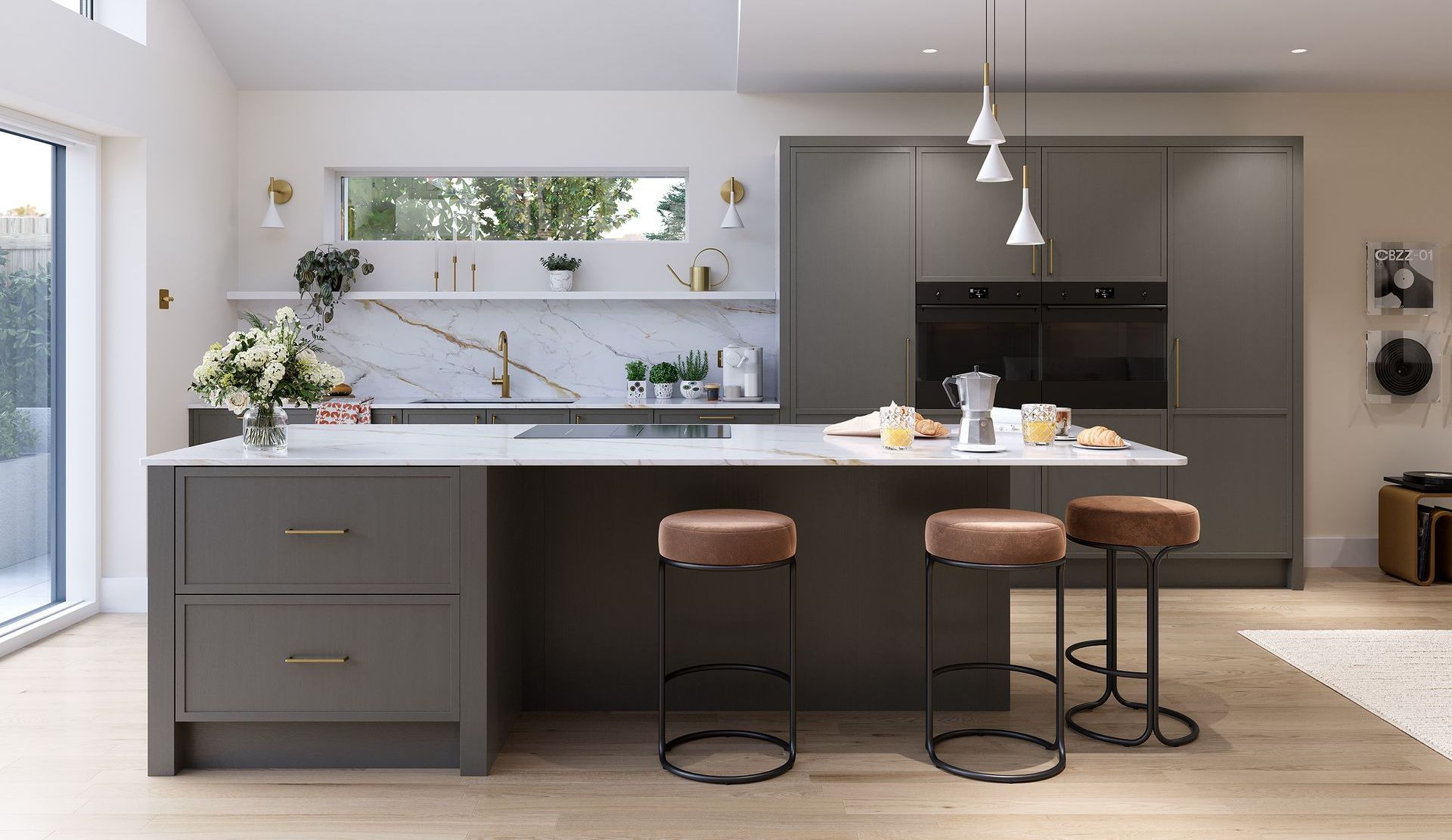 A modern kitchen featuring a dark grey island with three stools, white marble countertops, and light wood flooring.