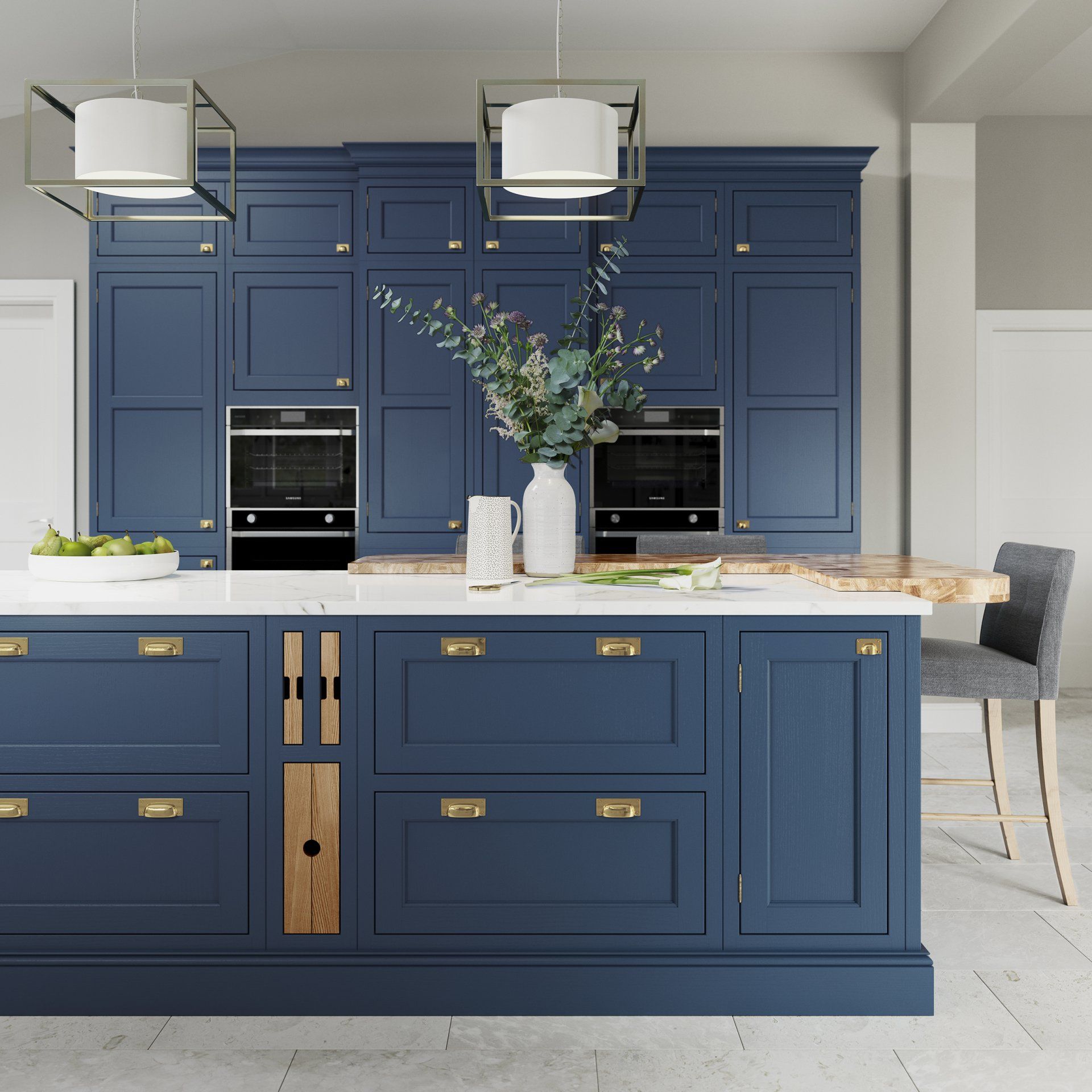 A modern kitchen with navy blue cabinetry, a white countertop island, gold hardware, and two square pendant lights.