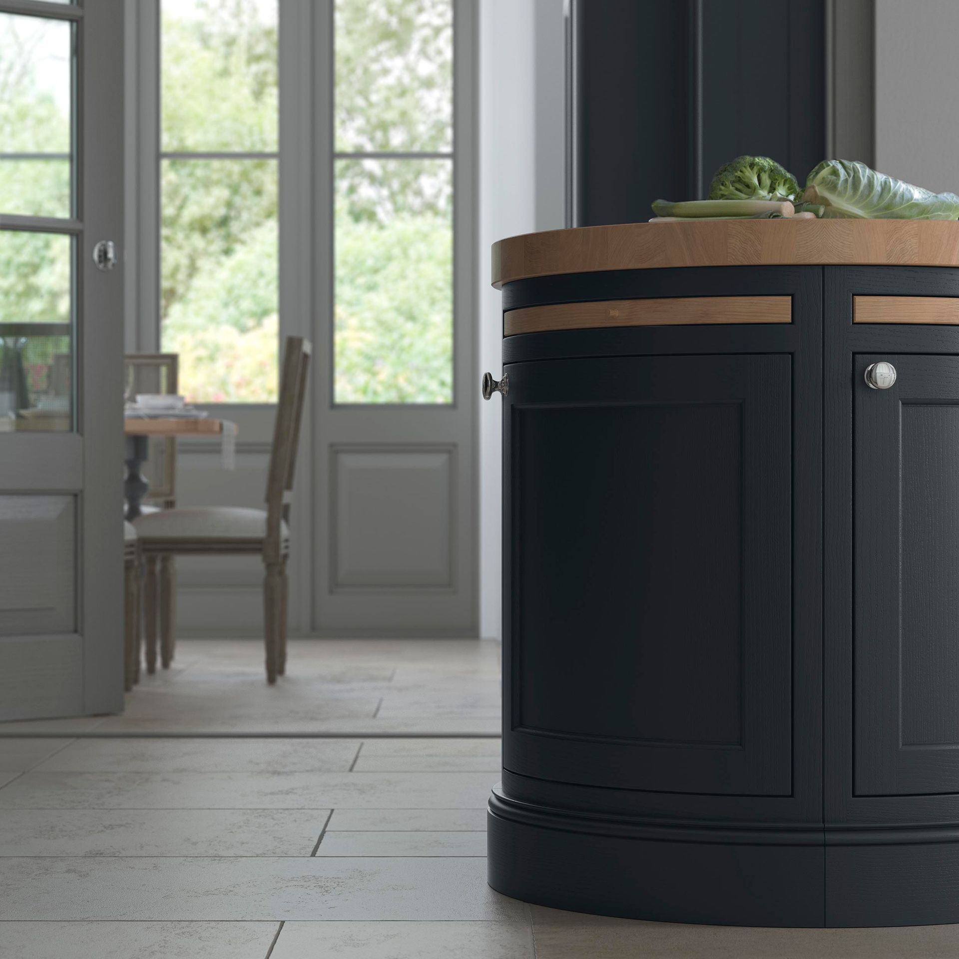 A dark navy, curved kitchen island with a wooden countertop stands in a light-flooded room with dining furniture.